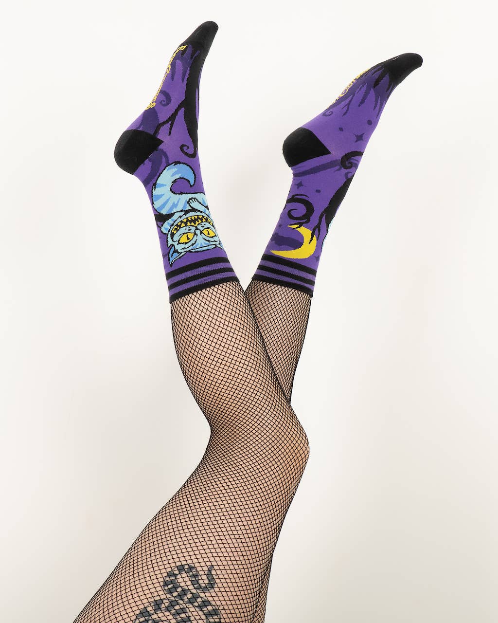 A model wearing a pair of socks featuring the cheshire cat. Purple legs, black heel, cuff and toe.
