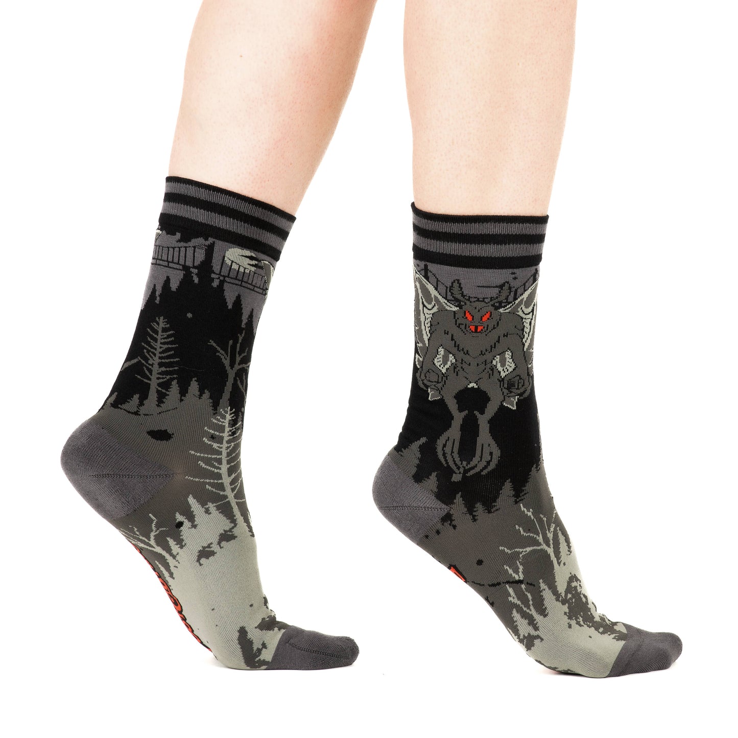 Model wearing a pair of socks featuring Mothman. Grey legs, grey heel, toe and cuff.