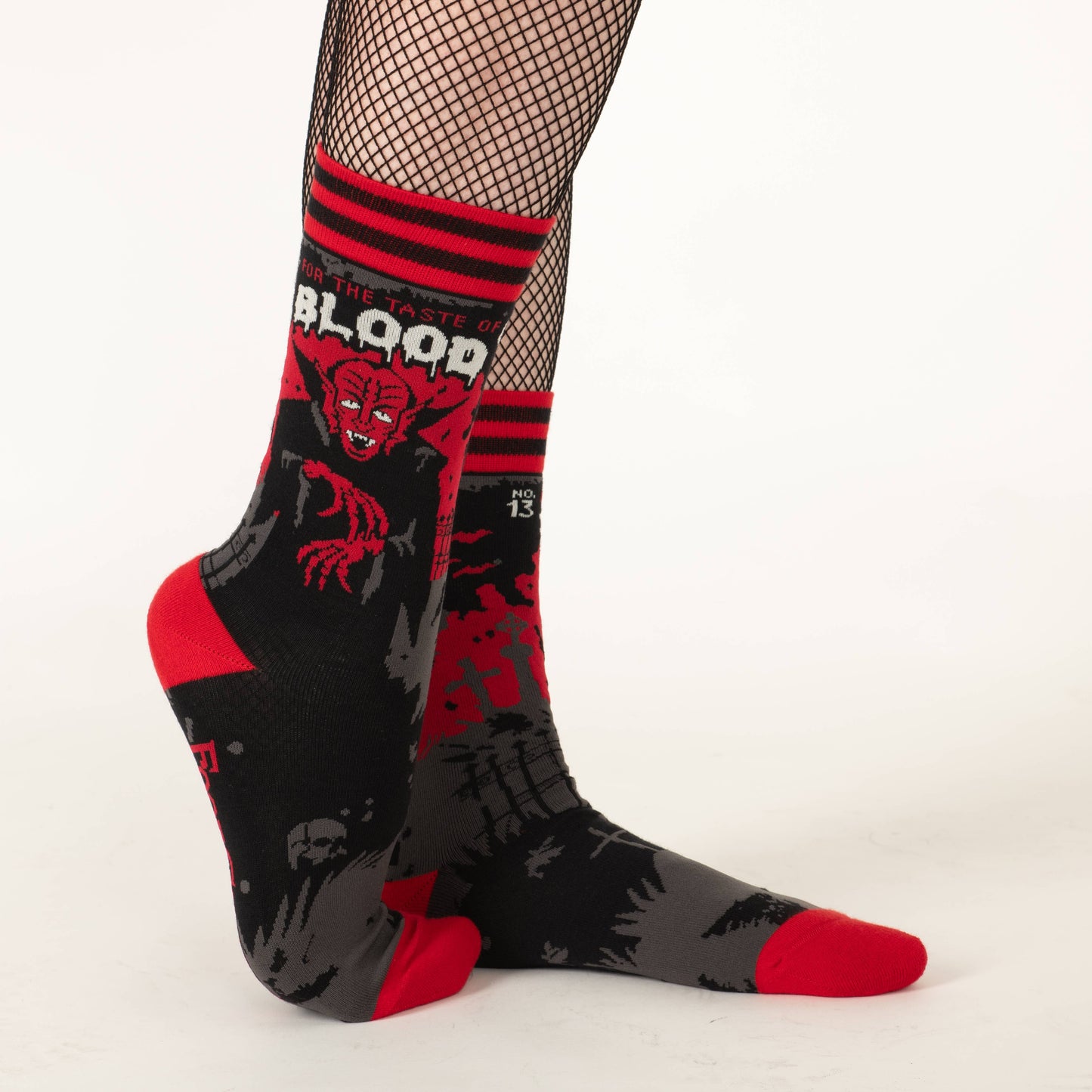 Model wearing a pair of socks depicting Dracula and a vampire slogan. Red cuff, heel and toe.