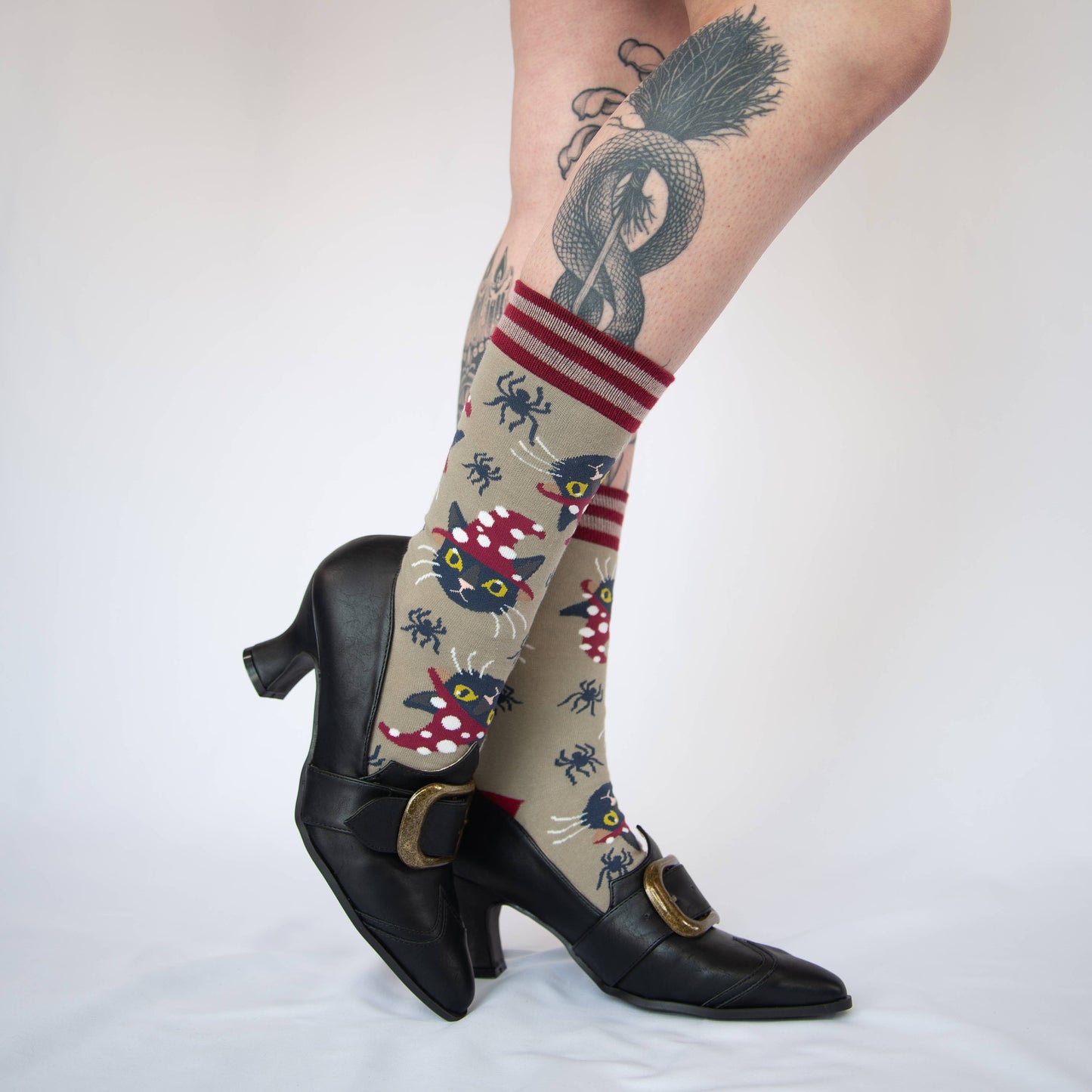 Model wearing a pair of cocks with a cute cat and spider halloween pattern. Red heel, toe and cuff.