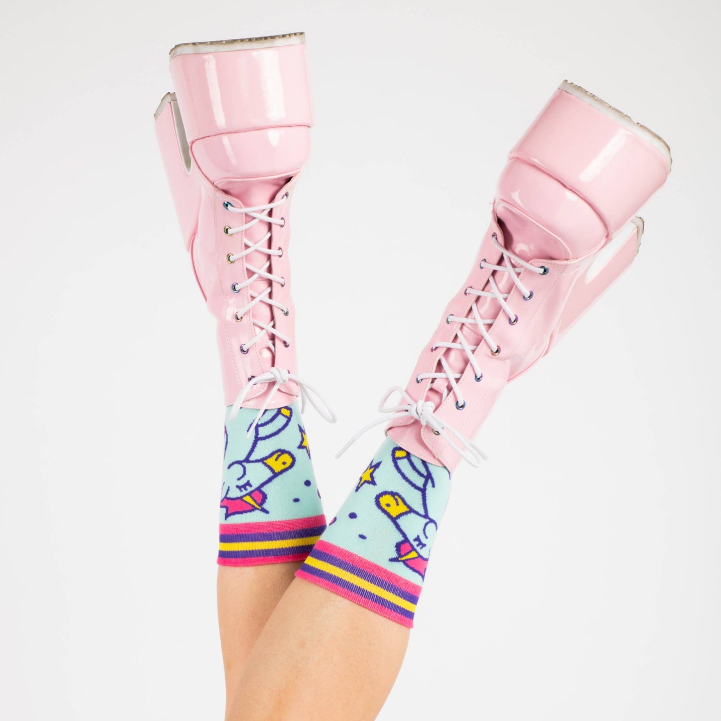 A model wearing a pair of socks featuring cute unicorns. Light blue legs, dark blue heel, toe and cuff.