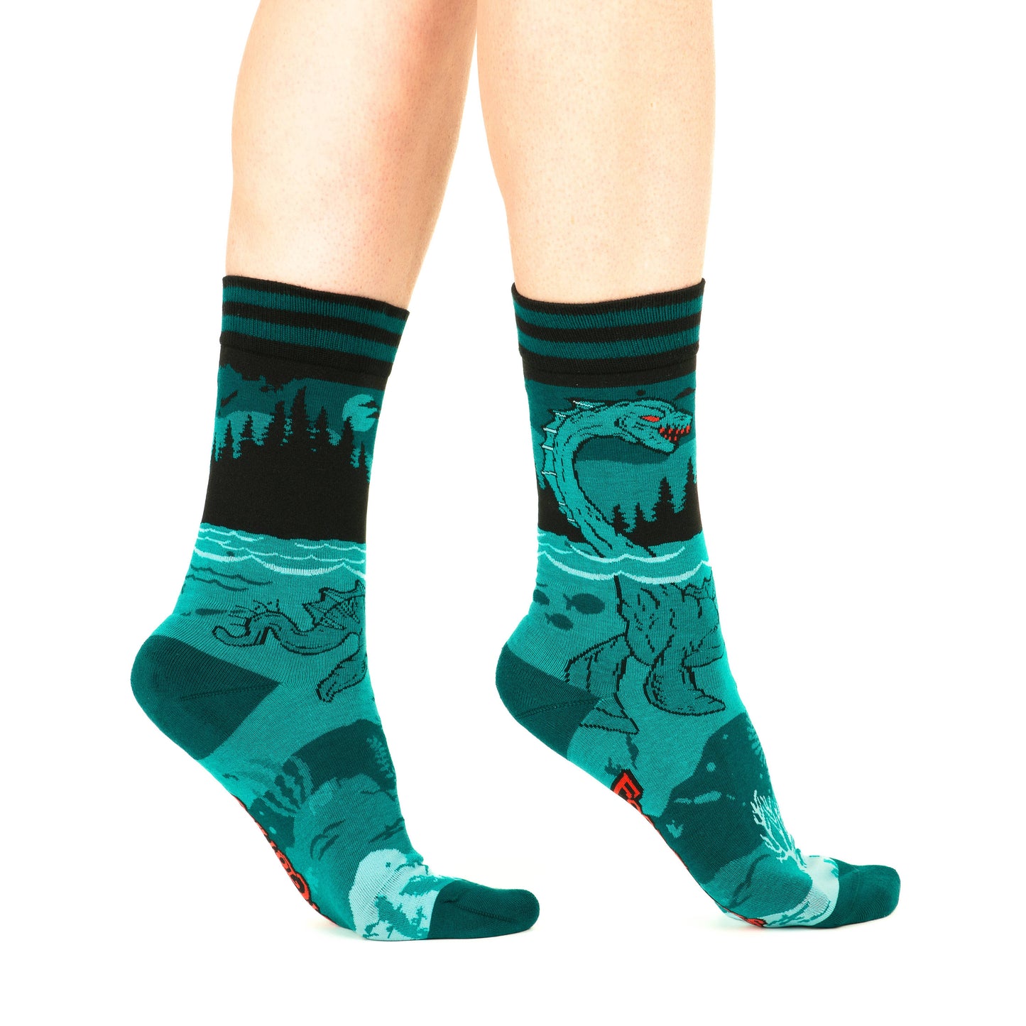A model wearing a pair of socks featuring the Loch Ness Monster. Blue legs, blue heel, toe and cuff.