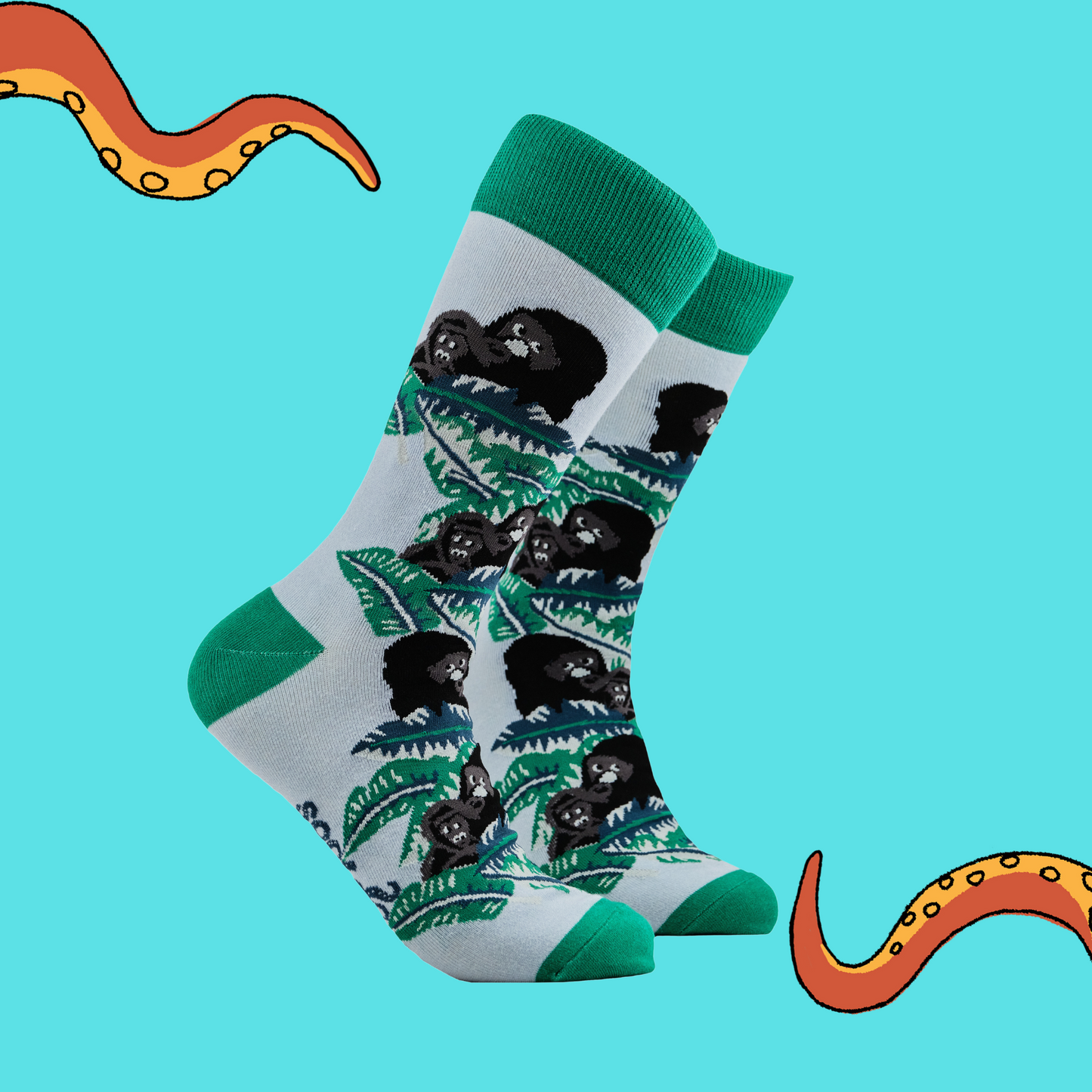 A pair of socks depicting gorillas in the forest. Green legs, green cuff, heel and toe.