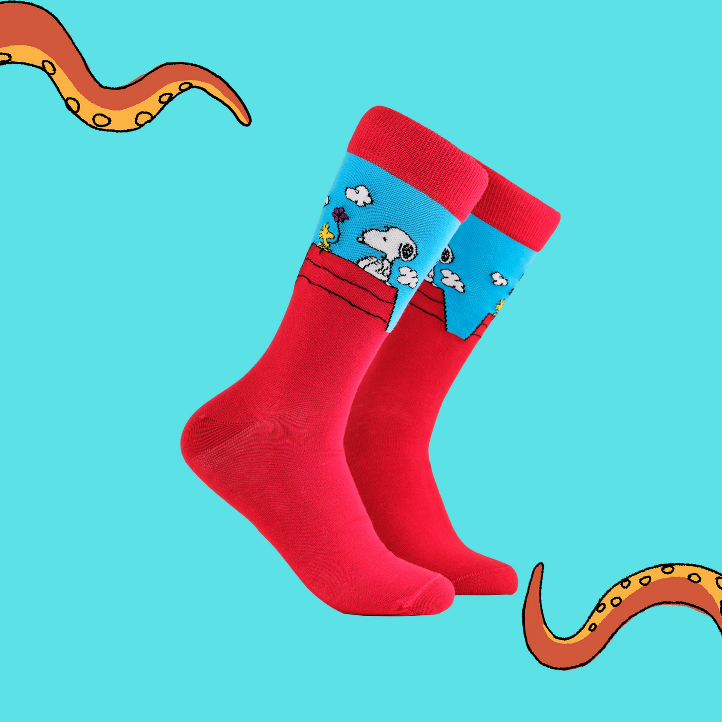 A pair of socks depicting snoopy and woodstock on the dog house. Red legs, red cuff, heel and toe.
