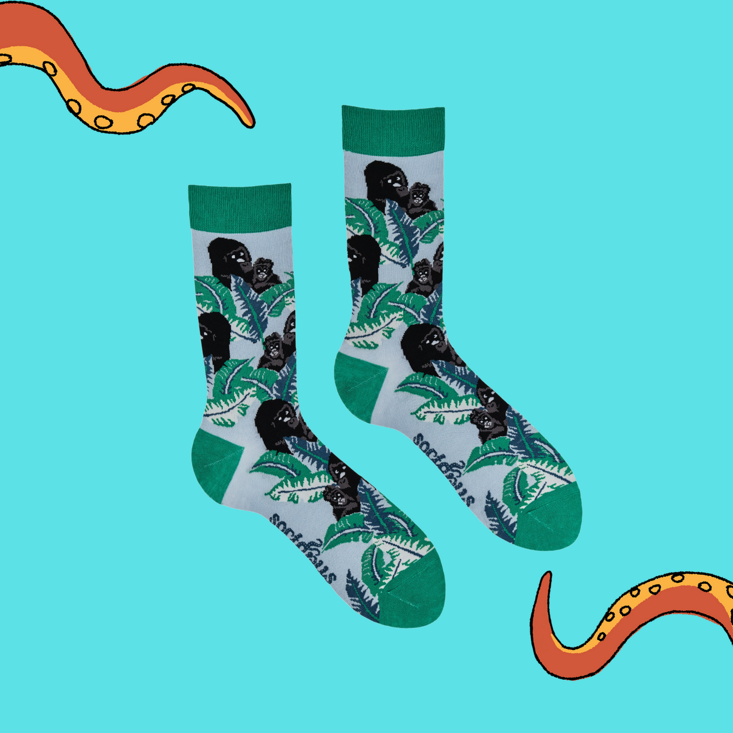 A pair of socks depicting gorillas in the forest. Green legs, green cuff, heel and toe.