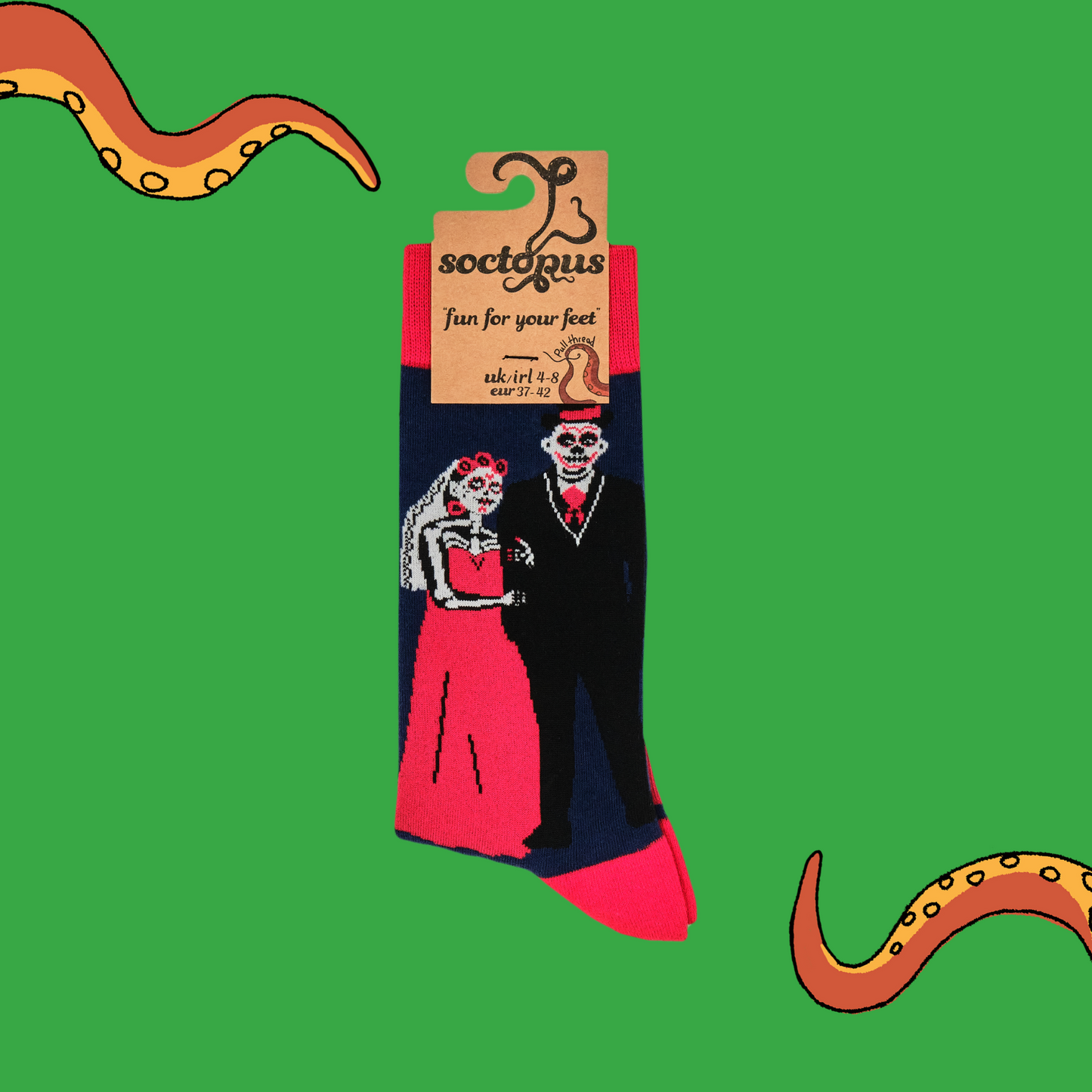 A pair of socks with a day of the dead motif. Dark blue legs, red heel, toe and cuff.
