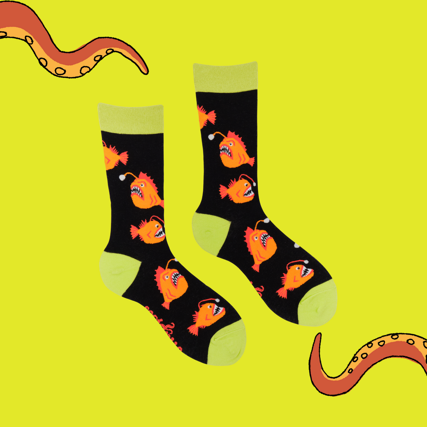 A pair of socks with an angler fish motif. Black legs, yellow heel toe and cuff