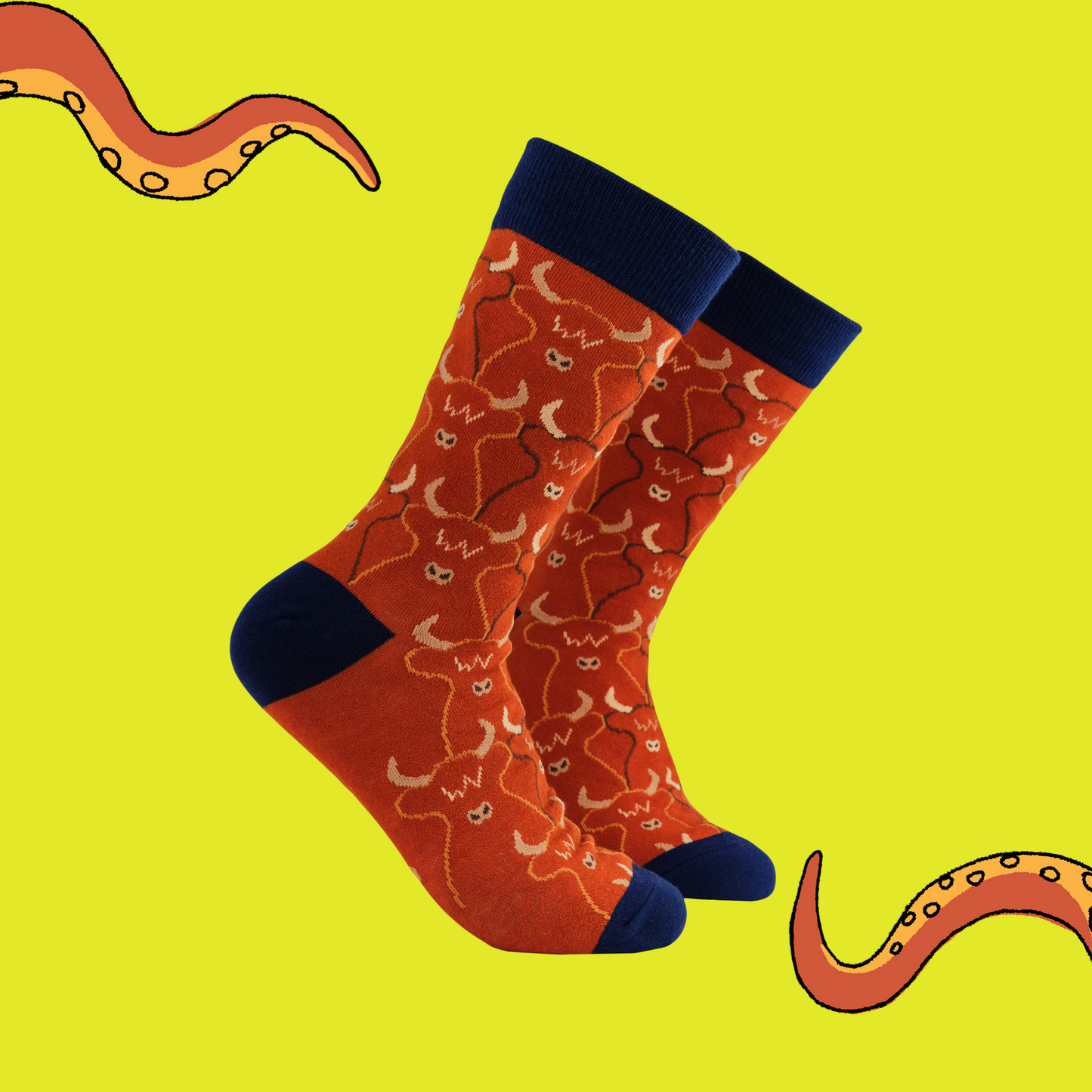 A pair of socks featuring a highland cow pattern. Ref legs, dark blue heel, toe and cuff.