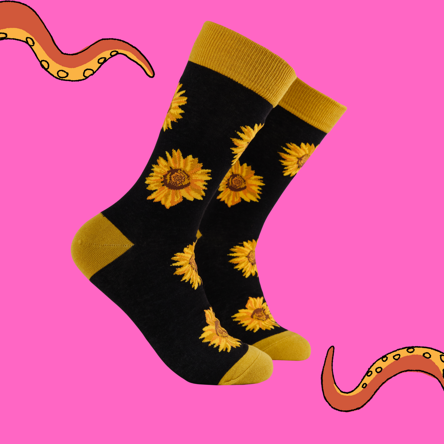 Black socks with sunflower pattern on a pink background.