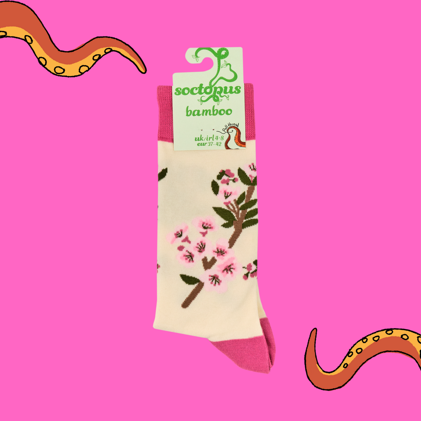 A pair of socks featuring cherry blossom. Beige legs, bright pink heel, toe and cuff.