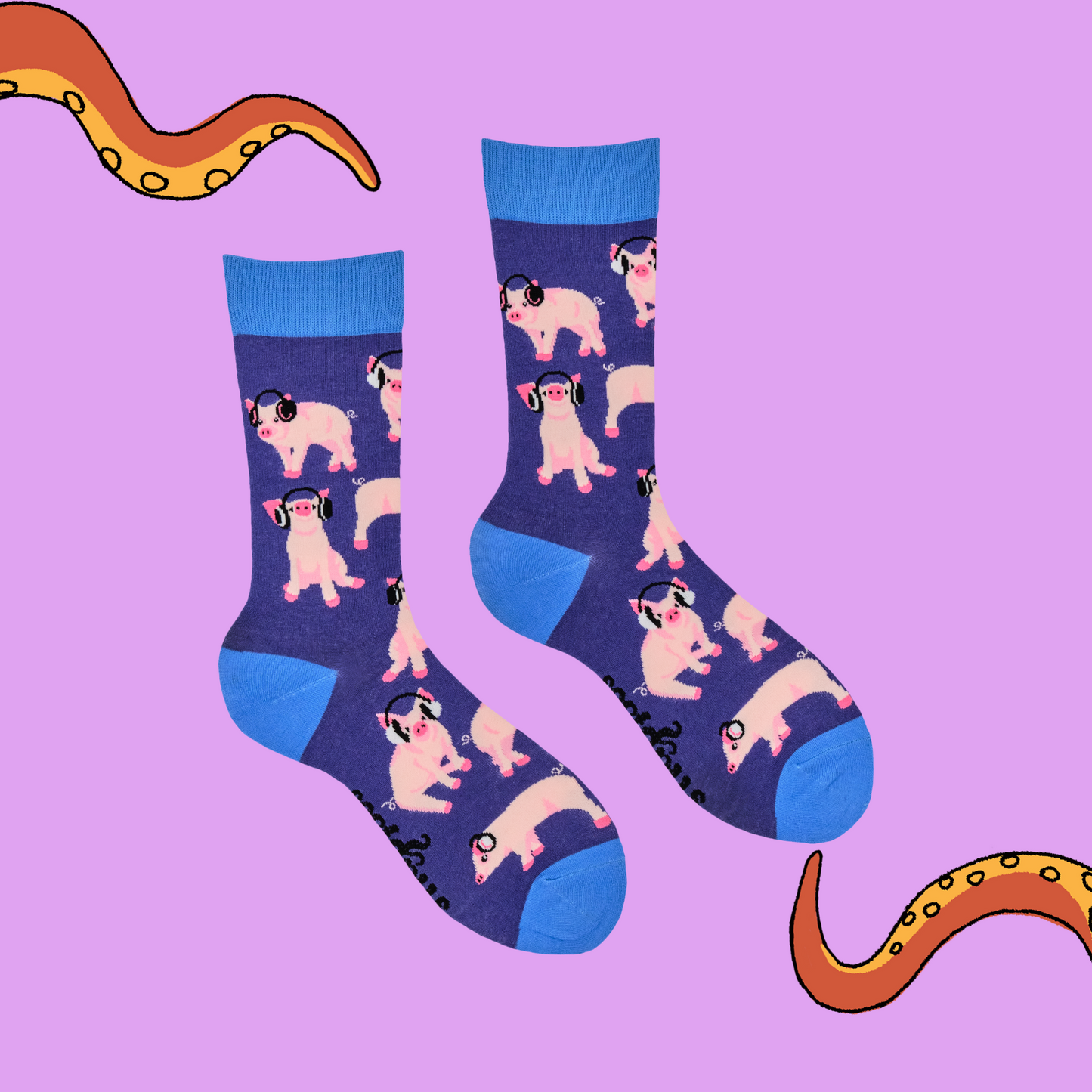 A pair of socks depicting Pigs being wearing headphones. Blue legs, Blue cuff, heel and toe. Pink background with Soktopus tentacles.