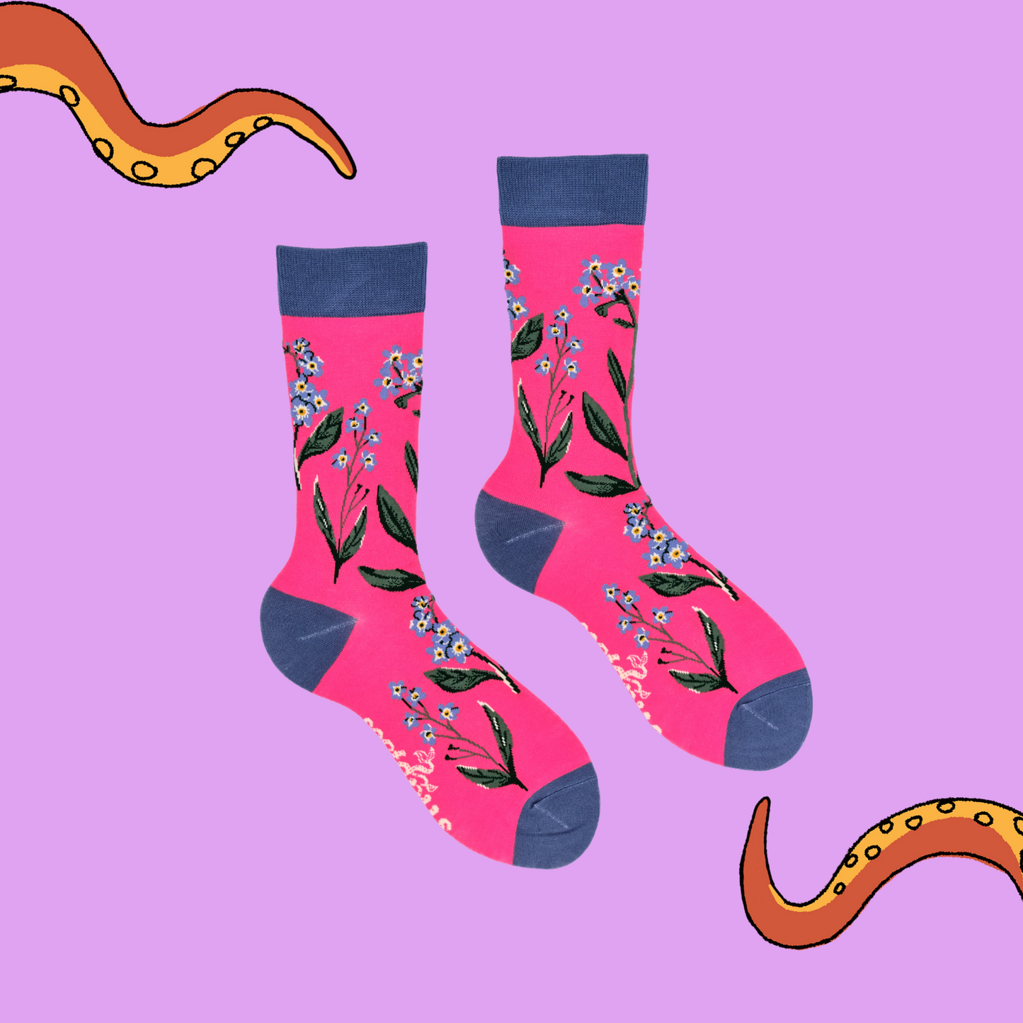 A pair of socks depicting forget me knot flowers. Pink legs, blue cuff, heel and toe.