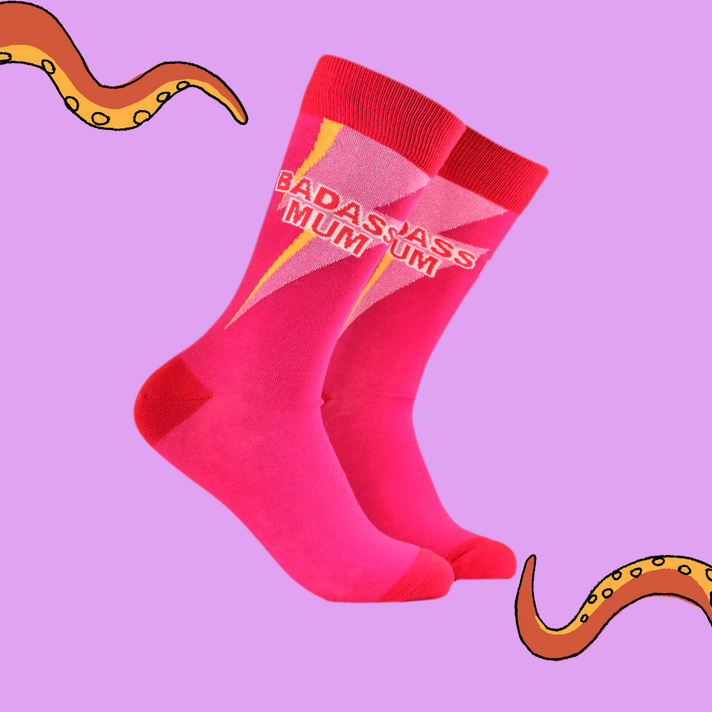 A pair of socks with he slogan Badass Mum. Pink legs, red heel, toe and cuff.