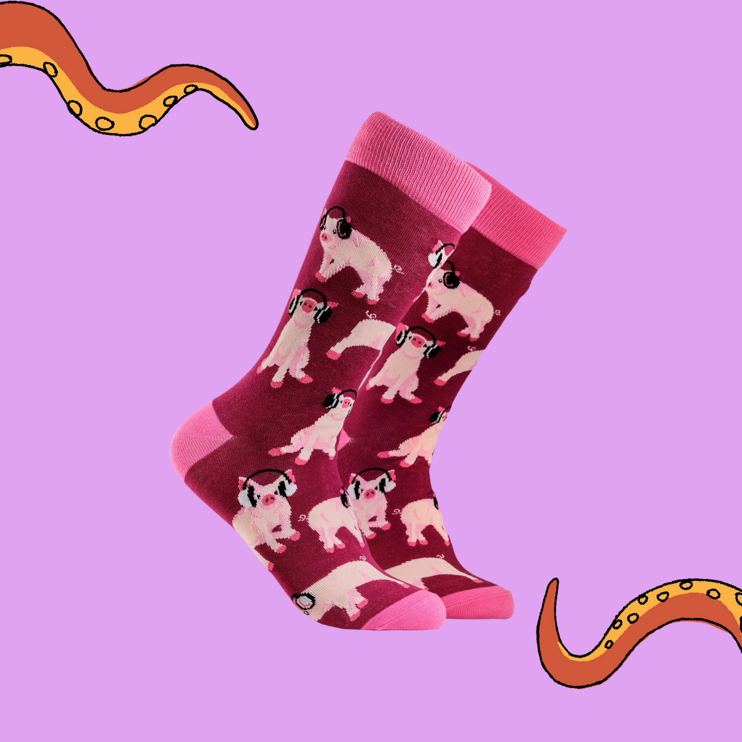 A pair of socks depicting Pigs being wearing headphones. Burgundy legs, pink cuff, heel and toe. Lilac background with Soctopus tentacles.