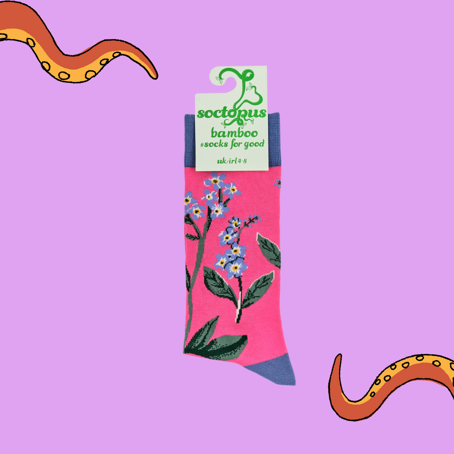 A pair of socks depicting forget me knot flowers. Pink legs, blue cuff, heel and toe. In Soctopus Packaging.