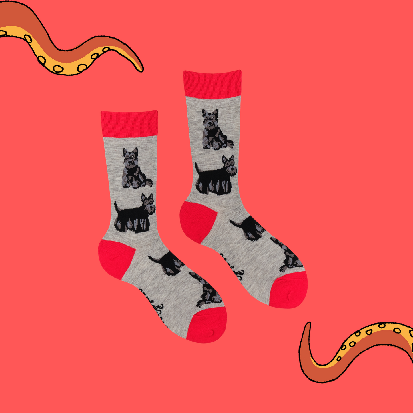 A pair of socks featuring a scottie dog motif. Grey legs, red heel toe and cuff.