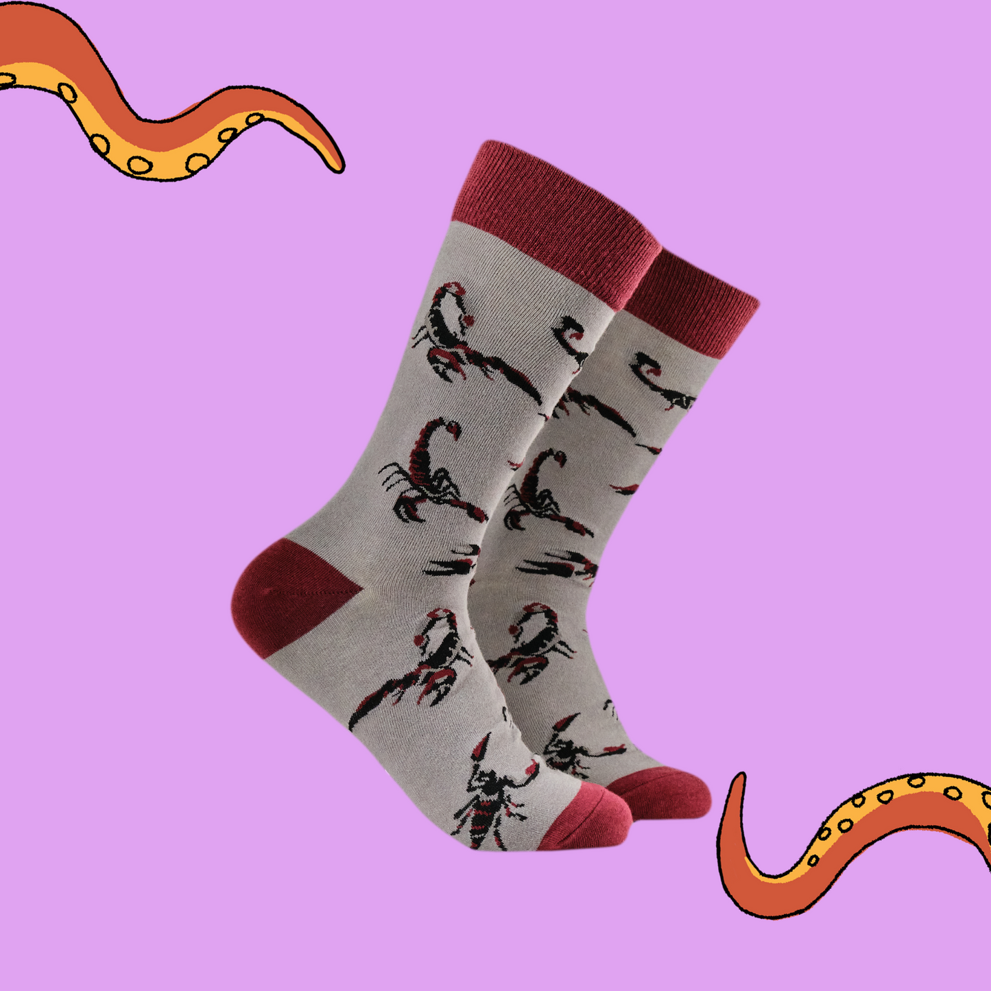 A pair of socks featuring a scorpion motif. Grey legs, red heel, toe and cuff.