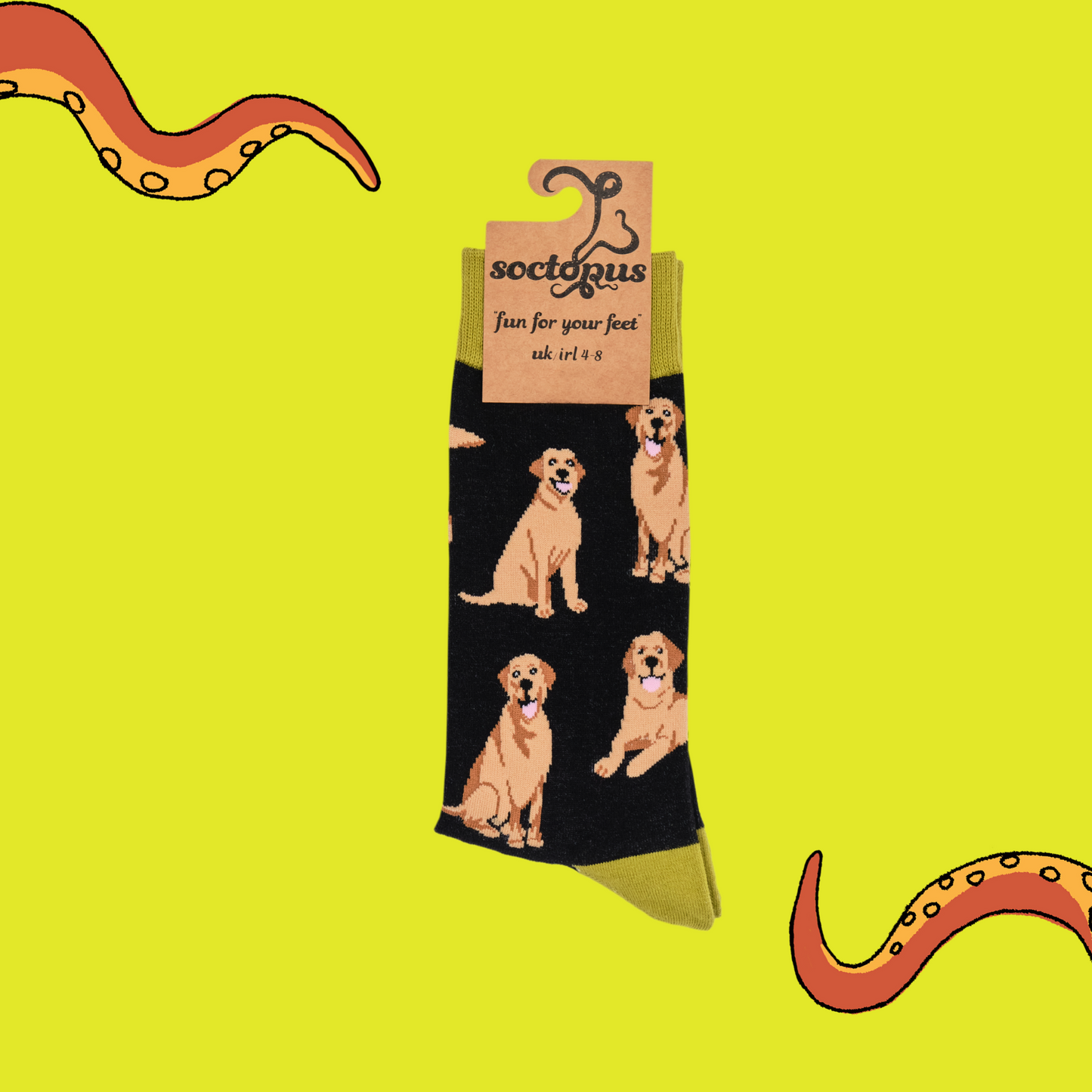 A pair of socks depicting Labrador dogs. Black legs, mustard cuff, heel and toe. In Socktopus Packaging.