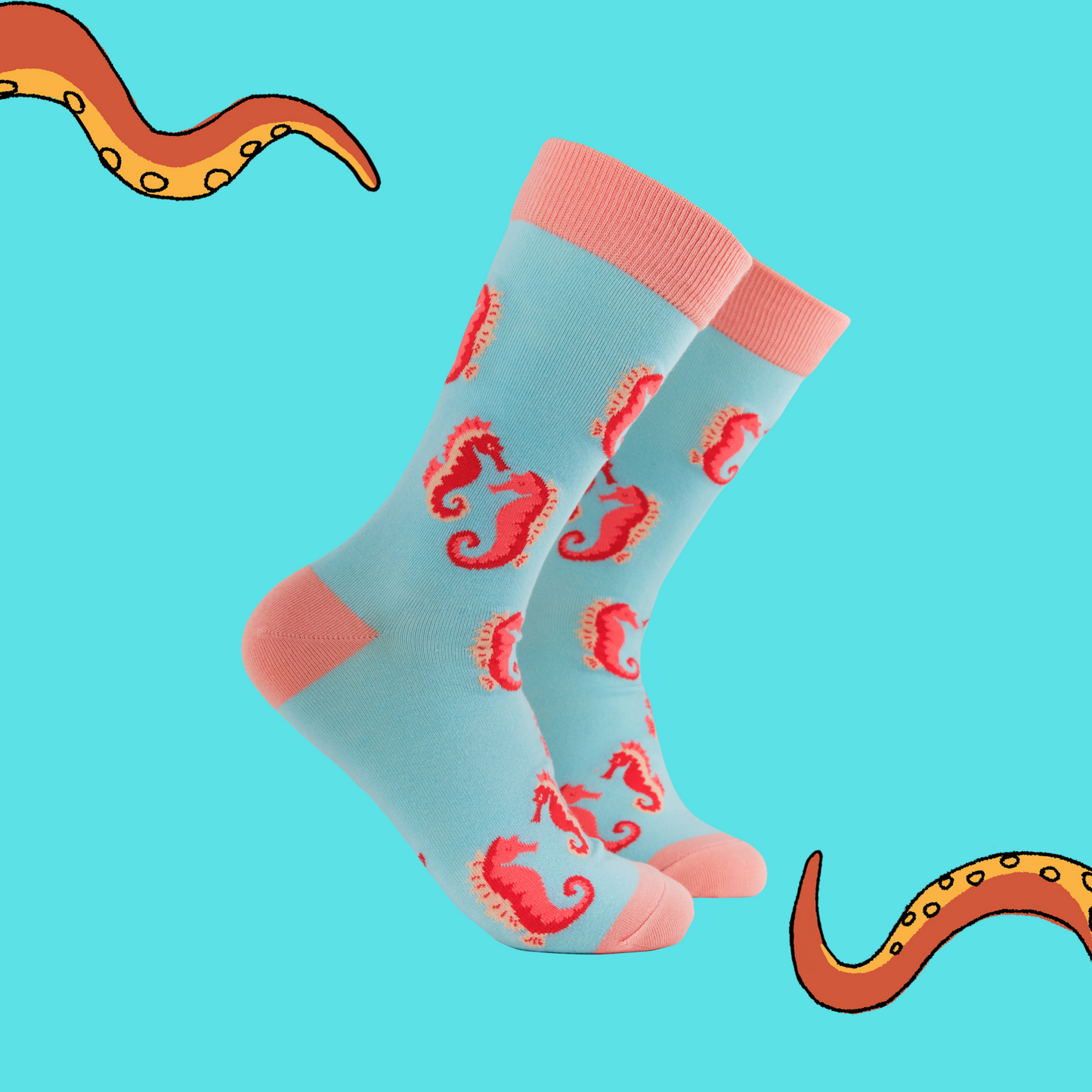 A pair of socks with a seahorse motif. Turquoise legs, pink heel, toe and cuff.