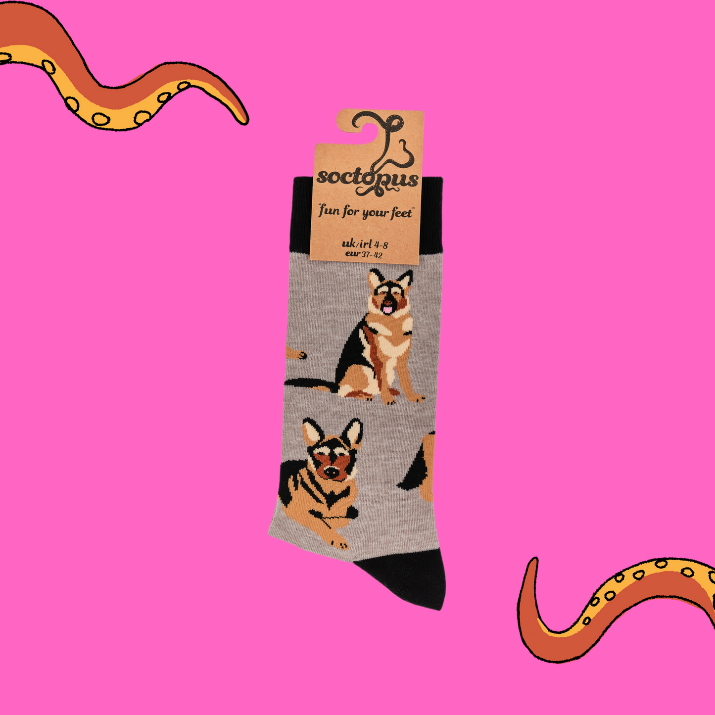 A pair of socks depicting German Shepherd dogs. Grey legs, black cuff, heel and toe. In Soctopus Packaging.