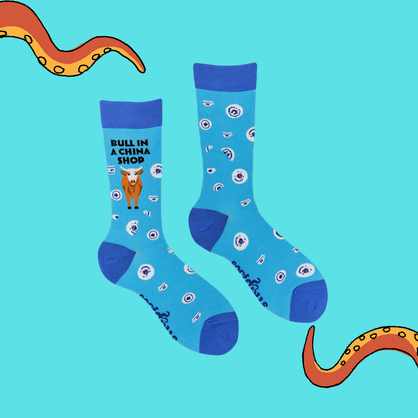A pair of socks featuring a bull in a china shop. Light blue legs, dark blue heel, toe and cuff.