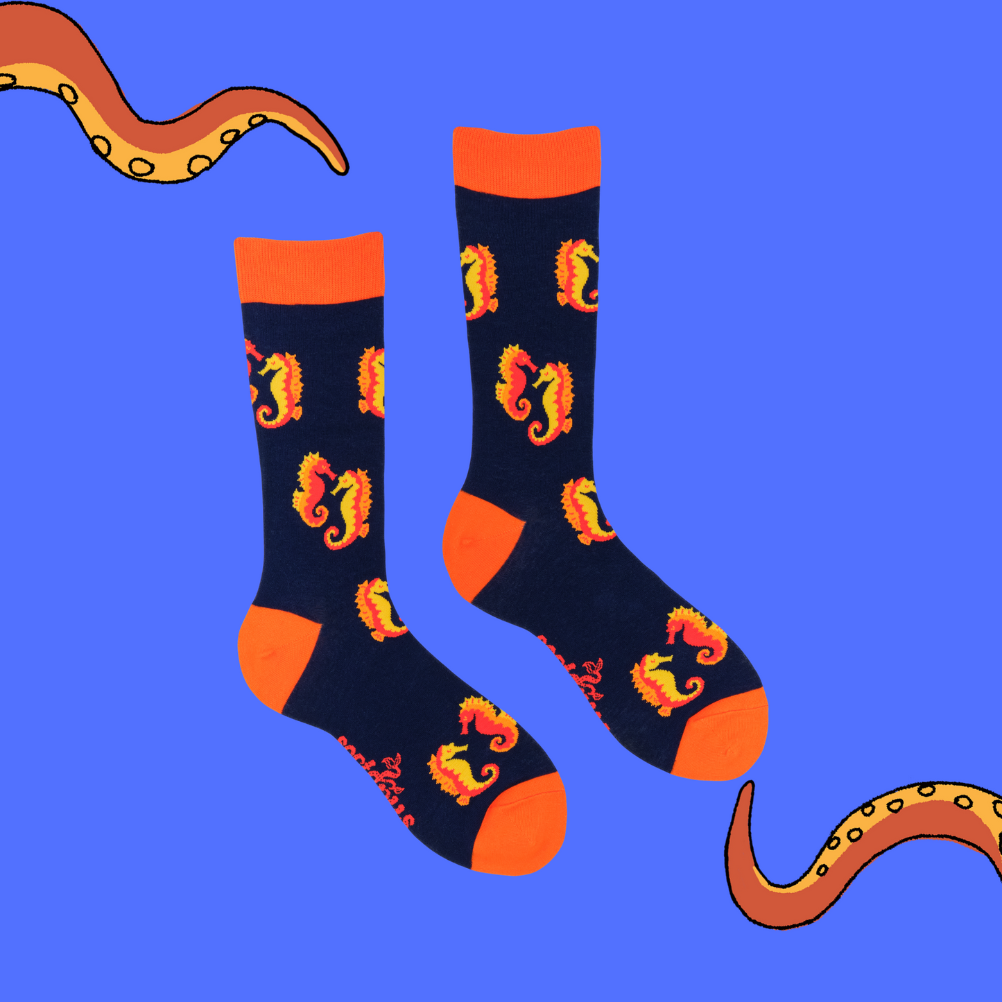 A pair of socks with a seahorse motif. Dark blue legs, red heel, toe and cuff.