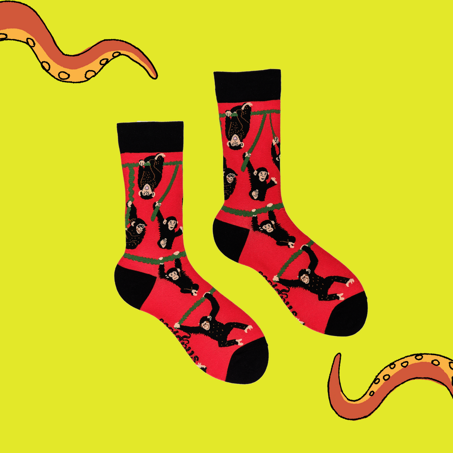 A pair of socks depicting playful chimpanzees. Red legs, black cuff, heel and toe.