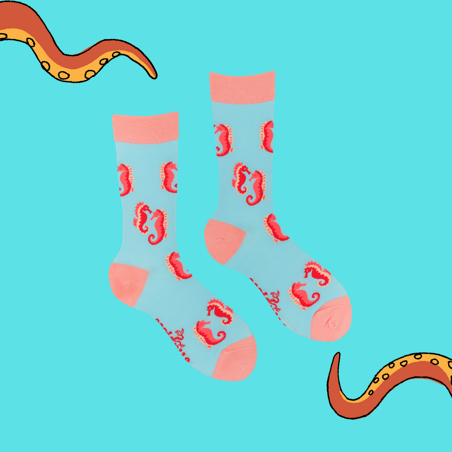 A pair of socks with a seahorse motif. Turquoise legs, pink heel, toe and cuff.