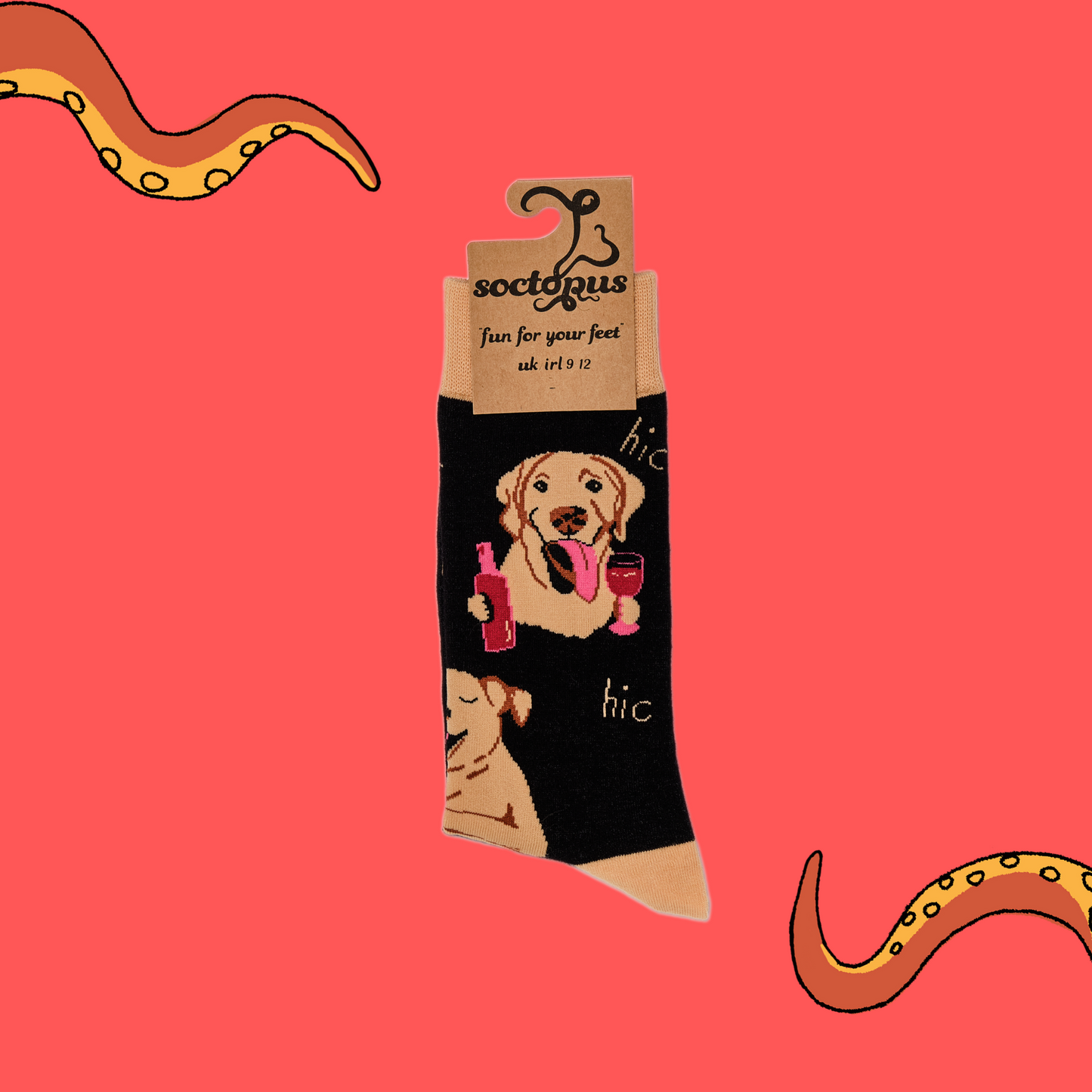 A pair of socks depicting labs drinking wine. Black legs, light brown cuff, heel and toe. In Socktopus Packaging.