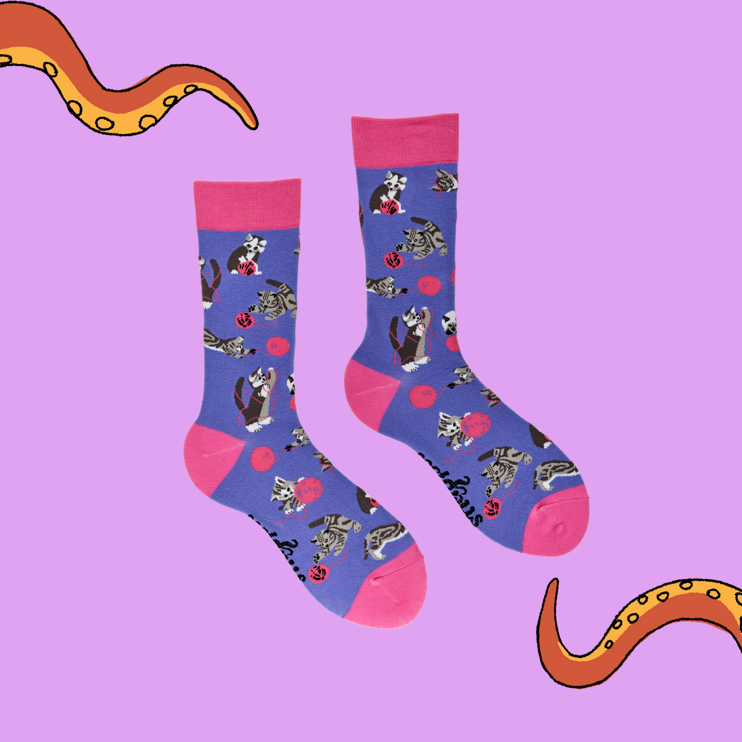 A pair of socks depicting cats playing with wool. Purple legs, pink cuff, heel and toe.