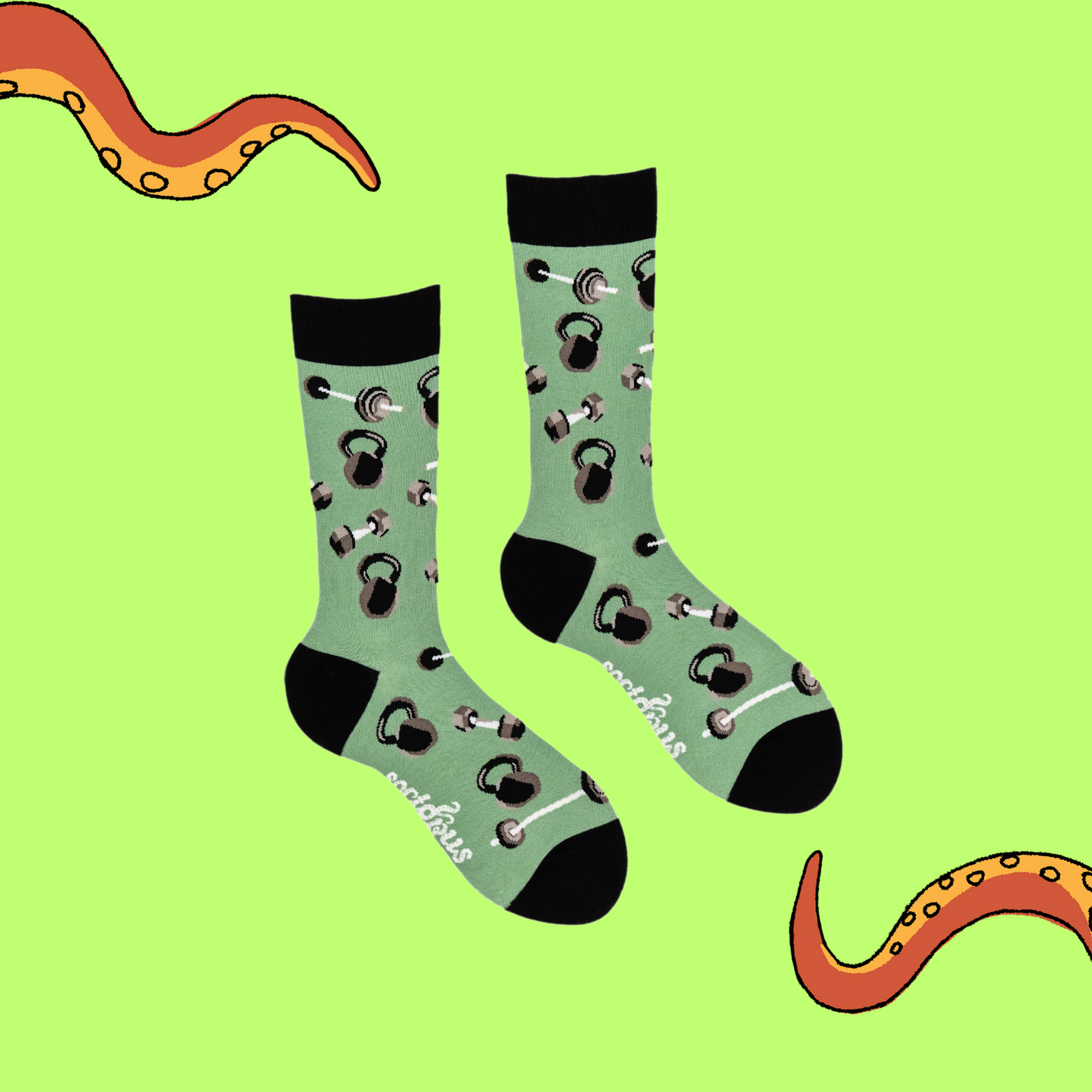 A pair of socks depicting dumb bells and kettle bells. Green legs, black cuff, heel and toe.