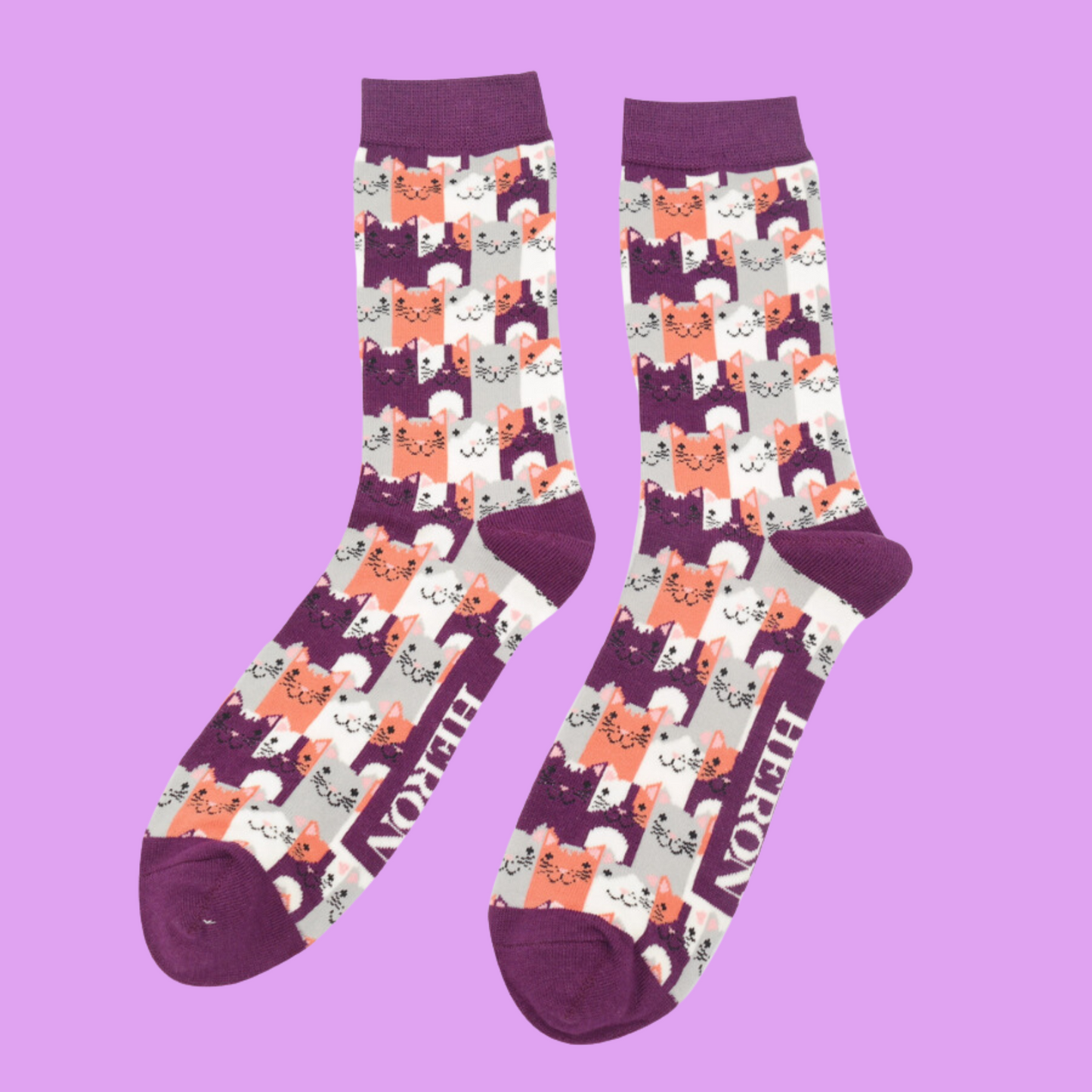 A pair of socks with a multicoloured happy anime cat pattern. Purple heel, toe and cuff.
