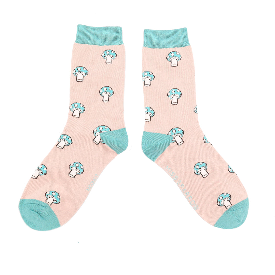 A pair of socks with a mushroom pattern. Peach legs, turquoise cuff, heel and toe.