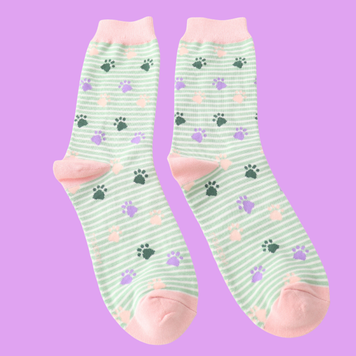 Paws and Stripes Bamboo Socks - Miss Sparrow. A pair of socks featuring white and mint green horizontal stripes, and a pink, purple, and green paw print pattern. Light pink cuffs, heels, and toes. Socks shown on a light purple background.