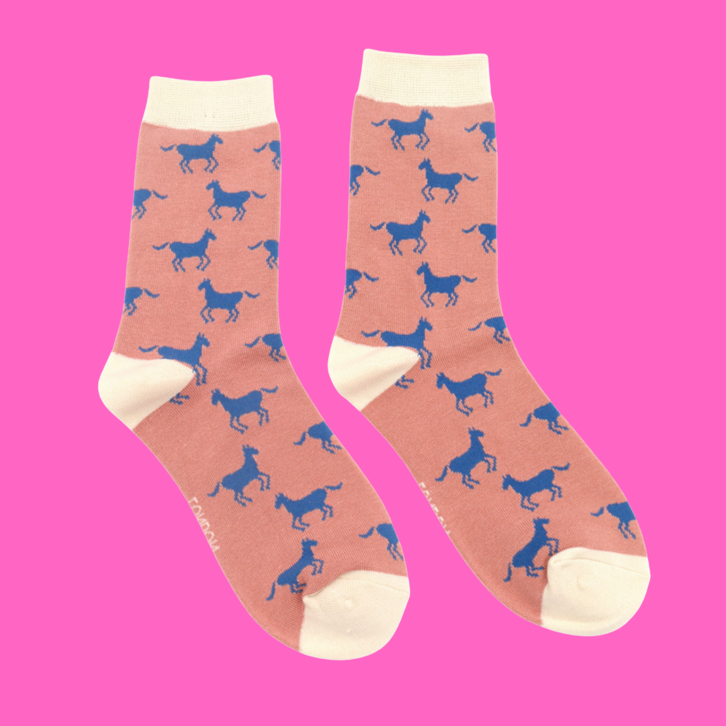 Horses Bamboo Socks - Miss Sparrow. A pair of light pink socks featuring a blue horse pattern. White cuffs, heels, and toes. Socks shown on a pink background.