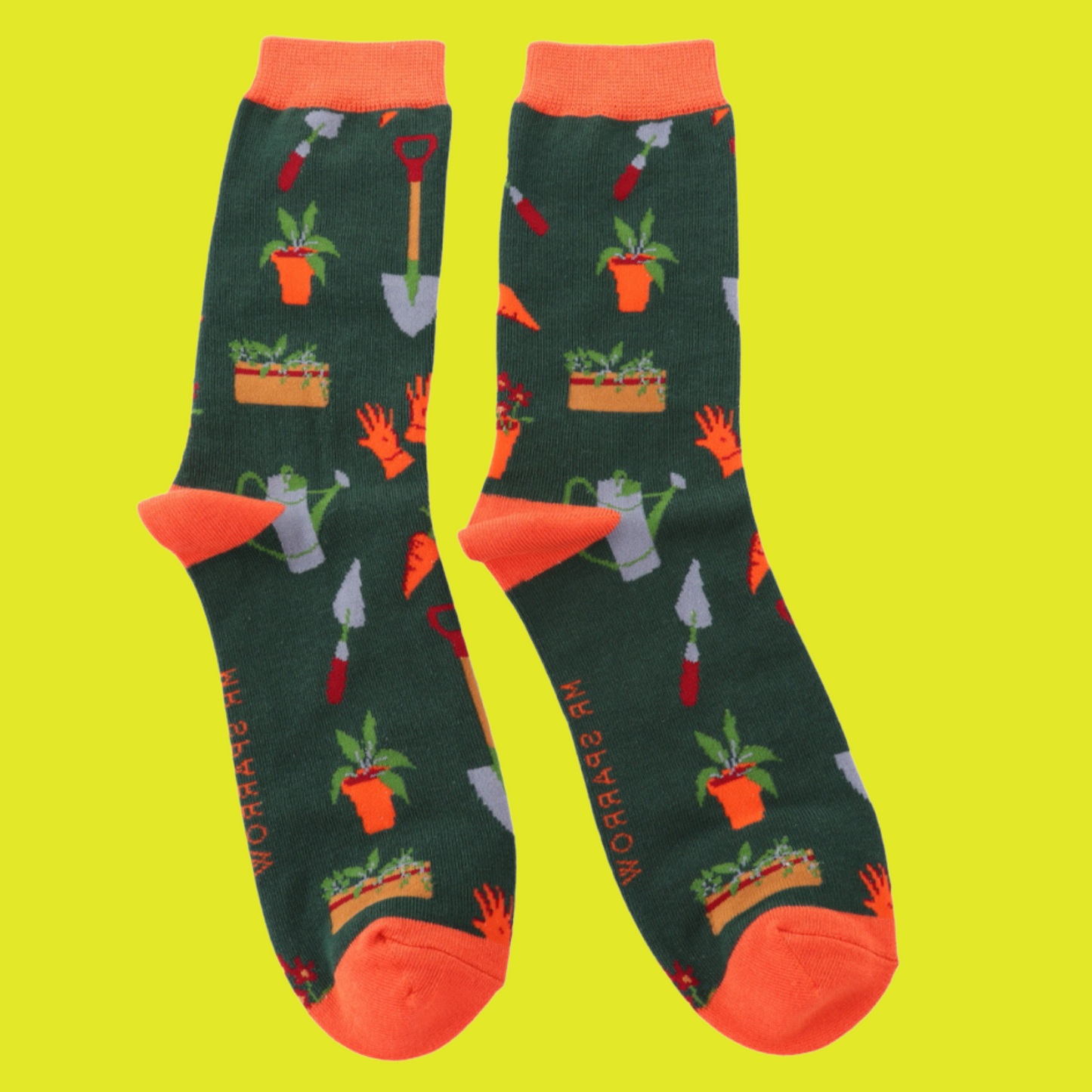 A pair of socks featuring gardeners tools, dark green legs, orange heel, toe and cuff.