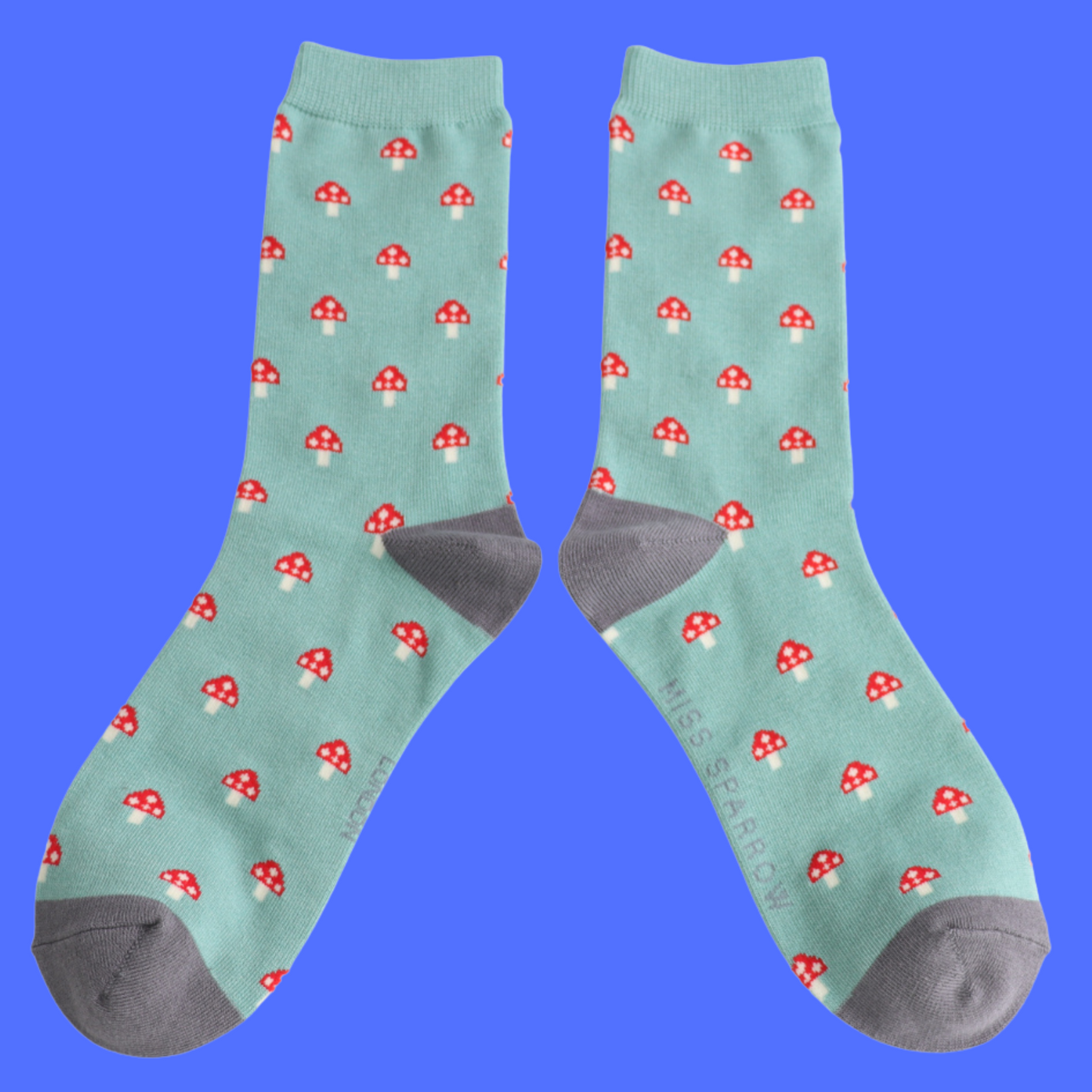 Little Mushrooms Bamboo Socks - Miss Sparrow. A pair of socks with a toadstool pattern. Green legs, grey heel and toe.