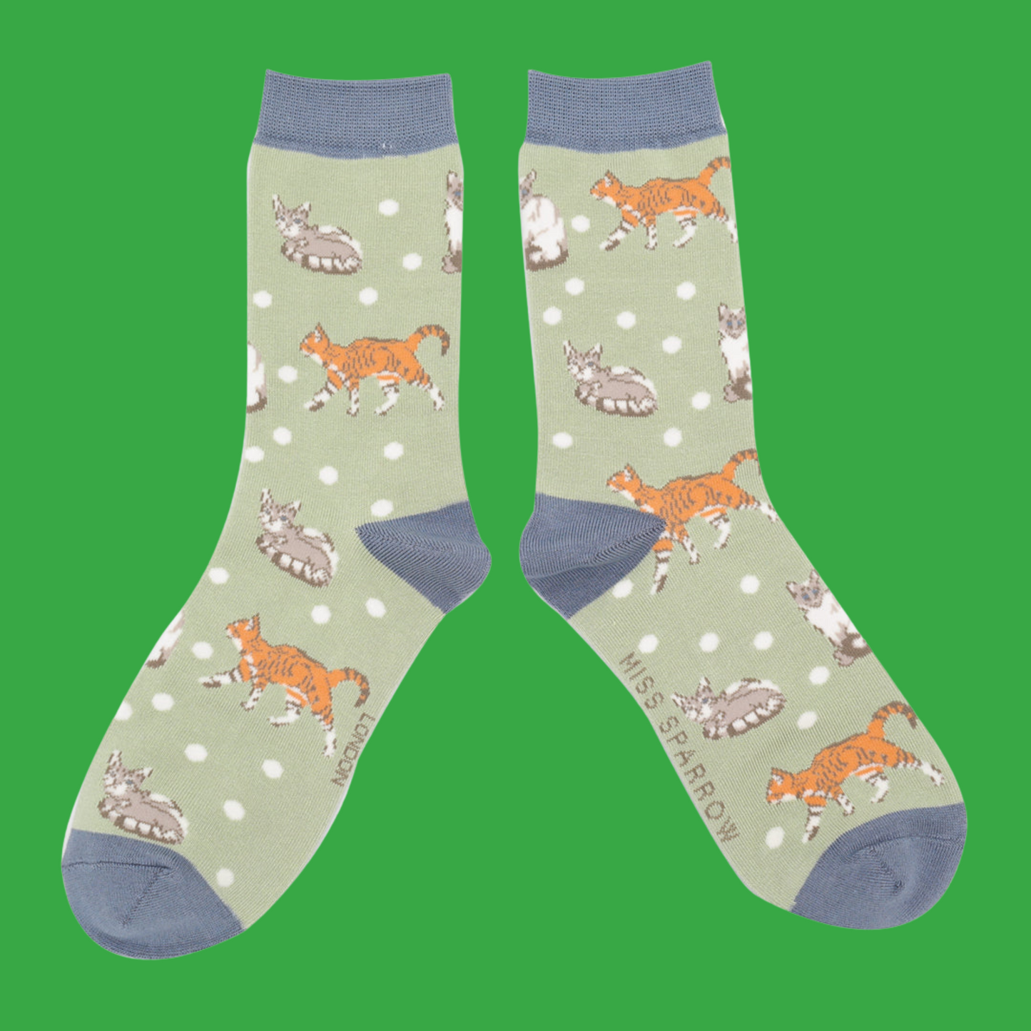 A pair of socks with a cat motif and spots pattern. Light green legs, blue heel, toe and cuff.