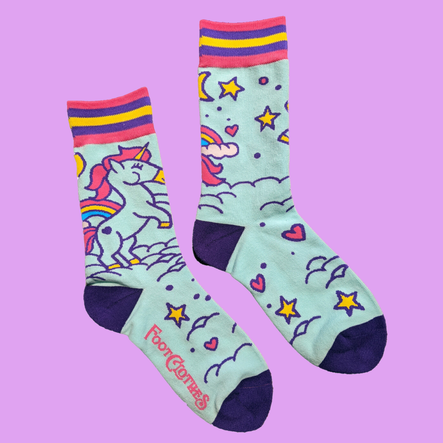 A pair of socks featuring cute unicorns. Light blue legs, dark blue heel, toe and cuff.