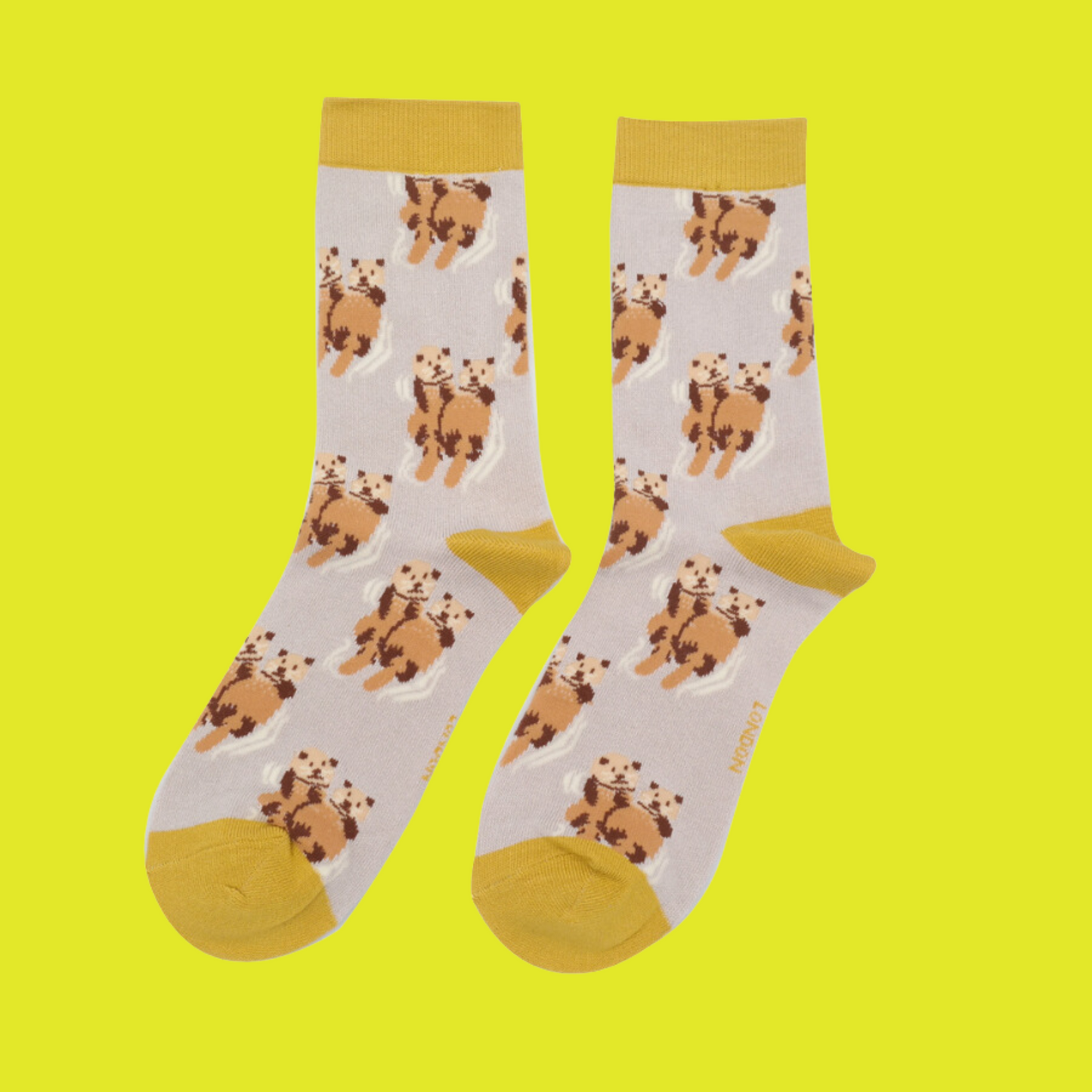 A pair of socks depicting otters holding hands. Cream legs, yellow heel, toe and cuff.