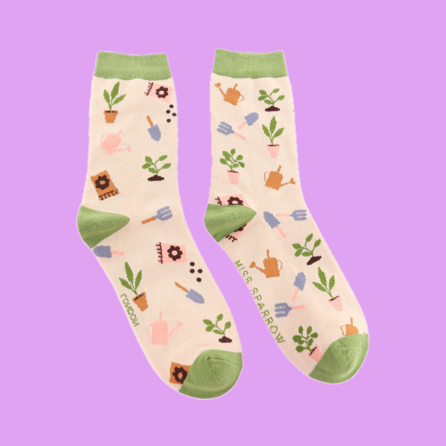 A pair of socks with an allotment motif. cream legs, green heel, toe and cuff.