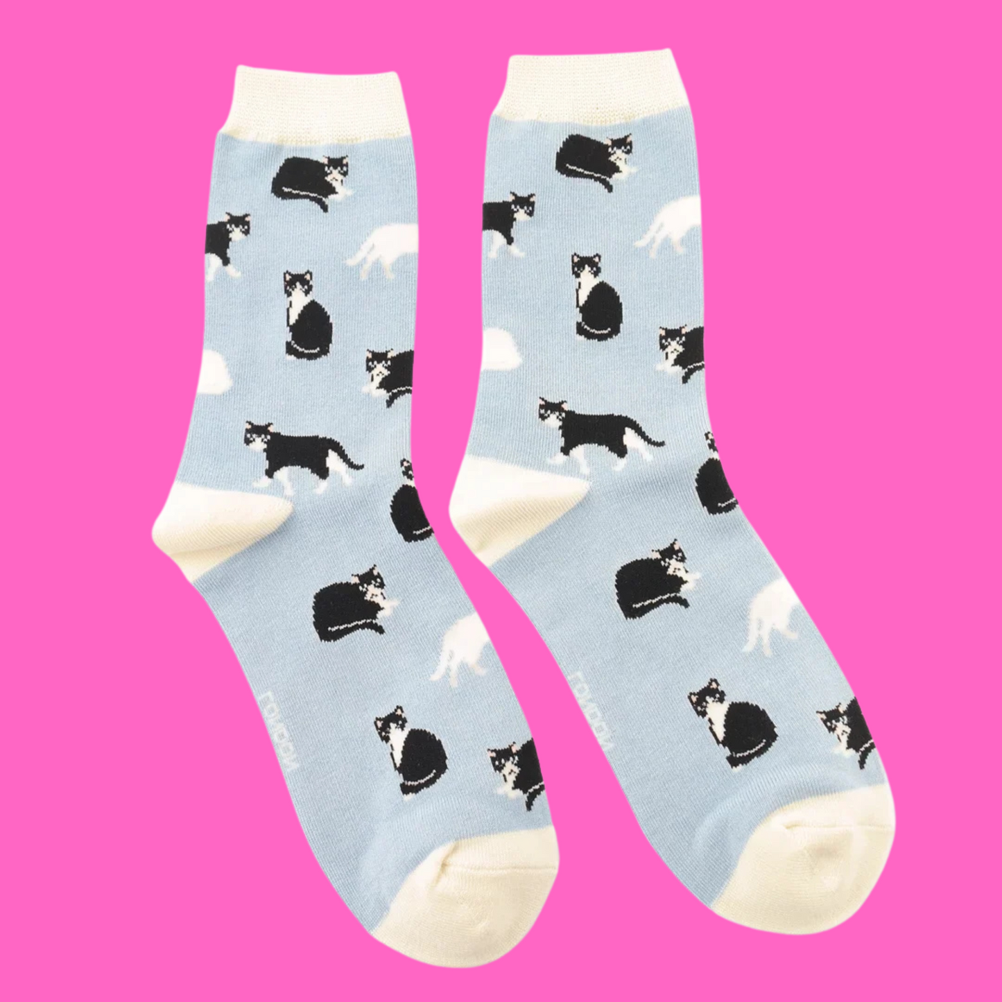A pair of socks featuring black and white cats. Light blue legs, white heel, toe and cuff.