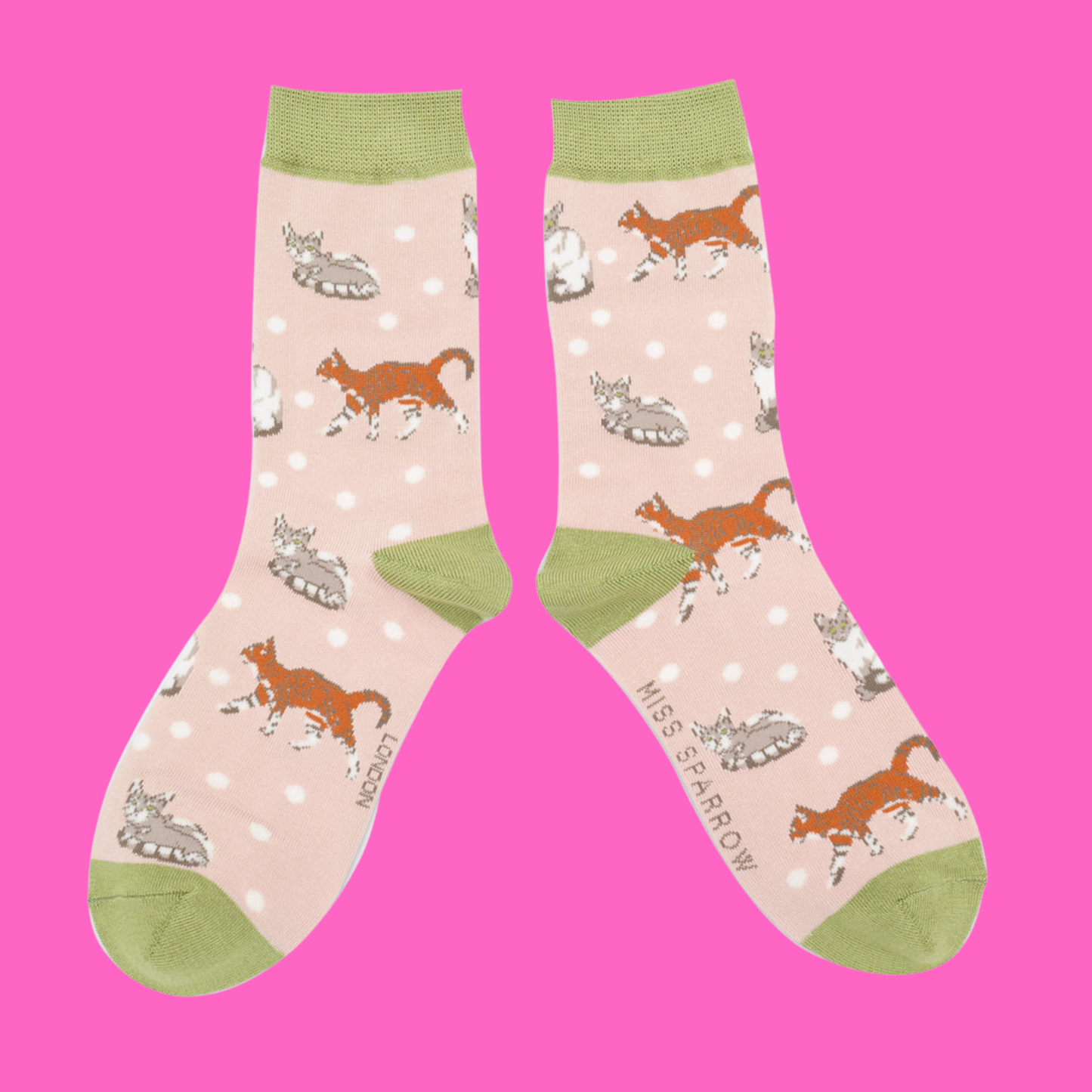 A pair of socks with a cat motif and spots pattern. Light pink legs, green heel, toe and cuff.