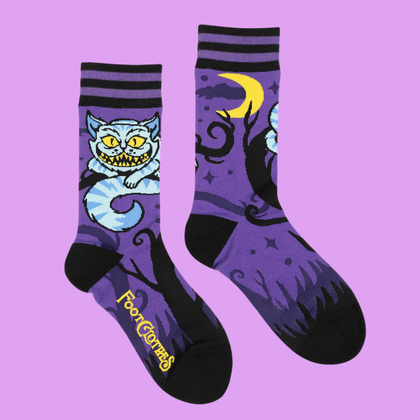 A pair of socks featuring the cheshire cat. Purple legs, black heel, cuff and toe.