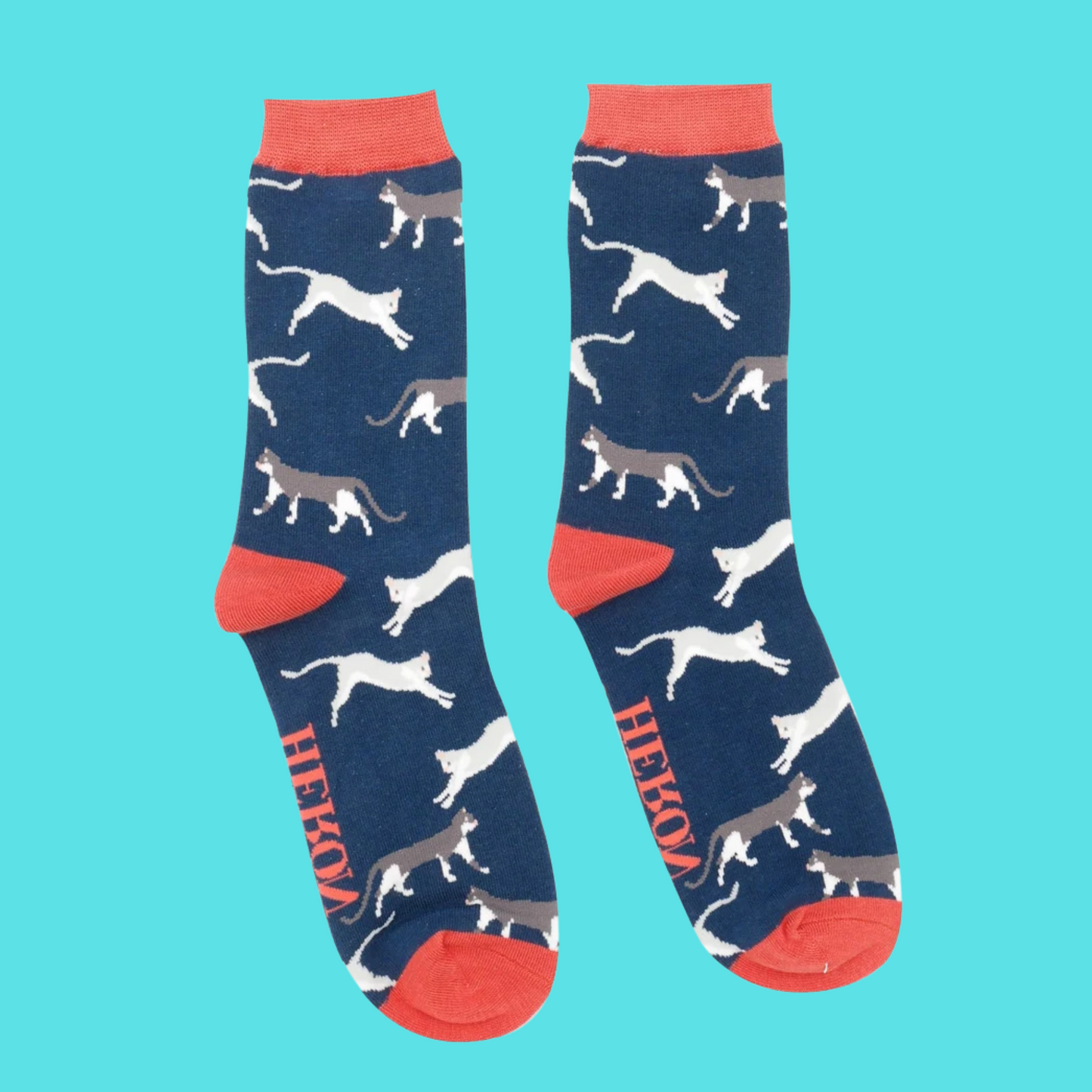 A pair of socks featuring wandering cats. Navy blue legs, red heel, toe and cuff.