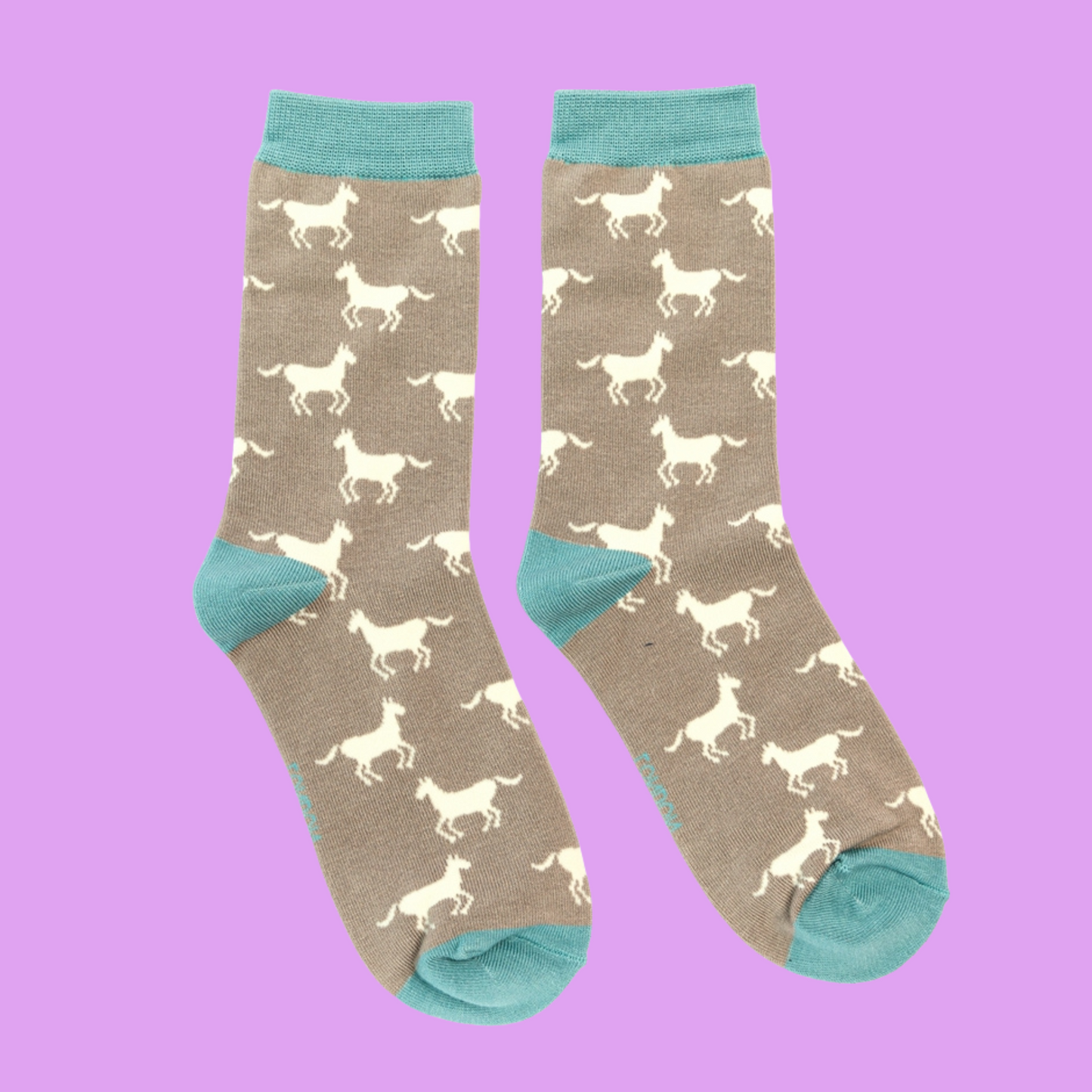 Horses Bamboo Socks - Miss Sparrow. A pair of grey beige socks featuring a white horse pattern. Light blue cuffs, heels, and toes. Socks shown on a light purple background.