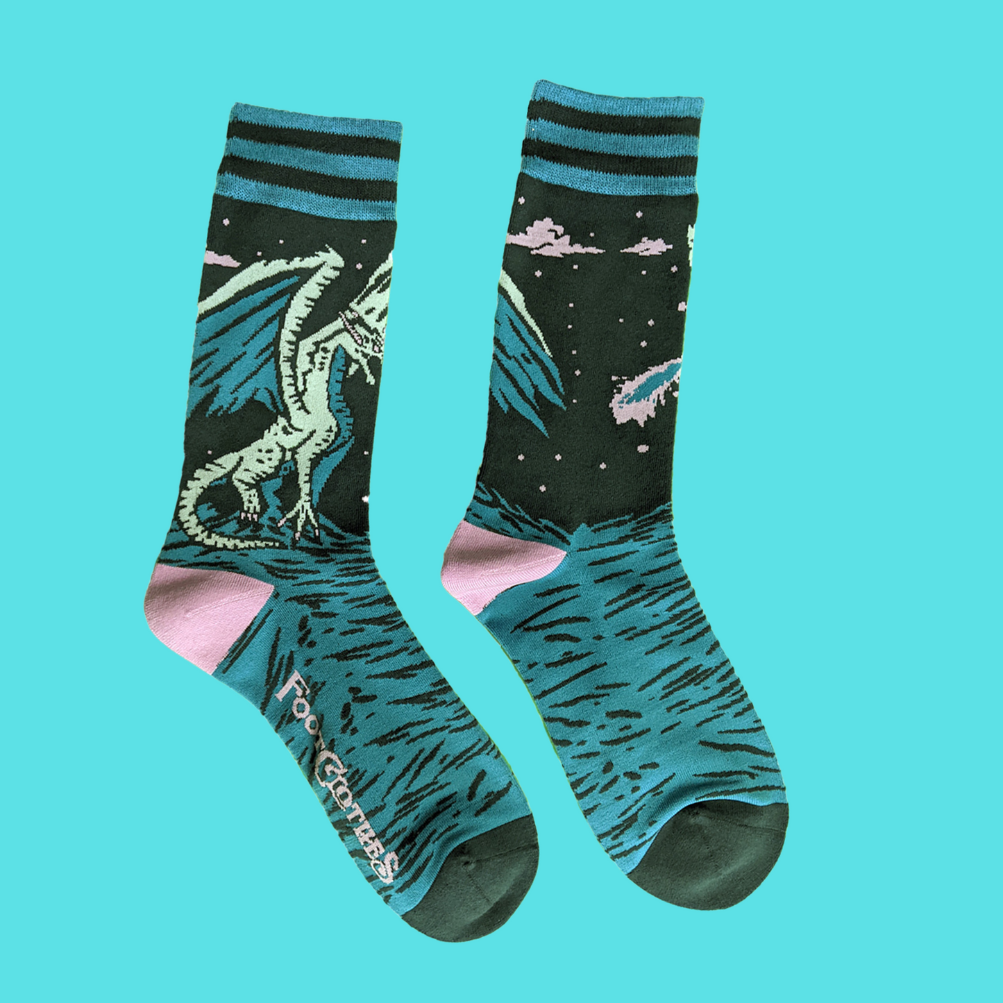 A pair of socks featuring an evil dragon. Blue legs, green heel, toe and cuff.