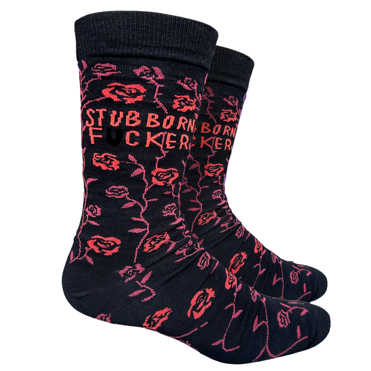 A pair of black socks with the text 'STUBBORN F***ER' repeated across the surface in a stylized font, accompanied by small red floral designs.