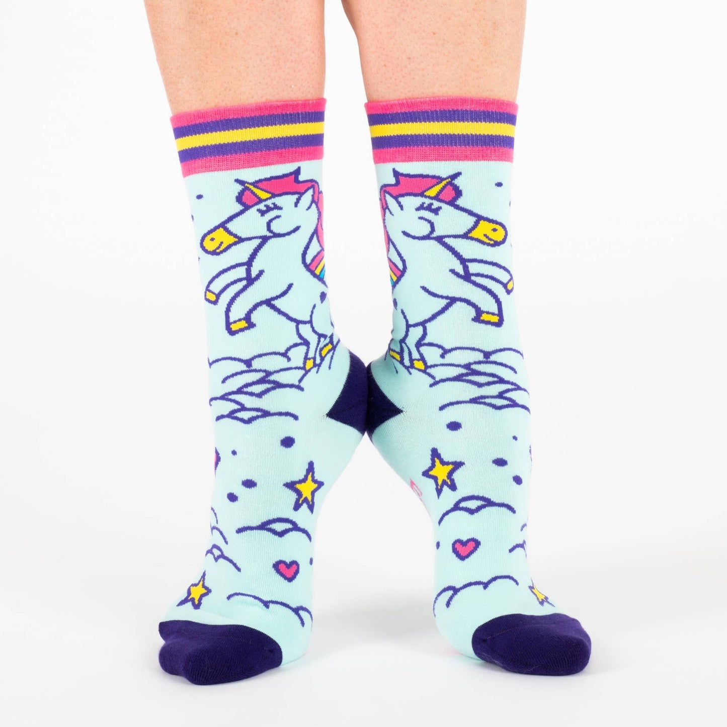A model wearing a pair of socks featuring cute unicorns. Light blue legs, dark blue heel, toe and cuff.