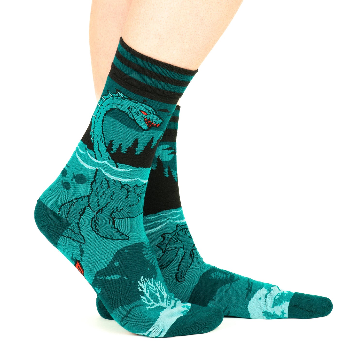 A model wearing a pair of socks featuring the Loch Ness Monster. Blue legs, blue heel, toe and cuff.
